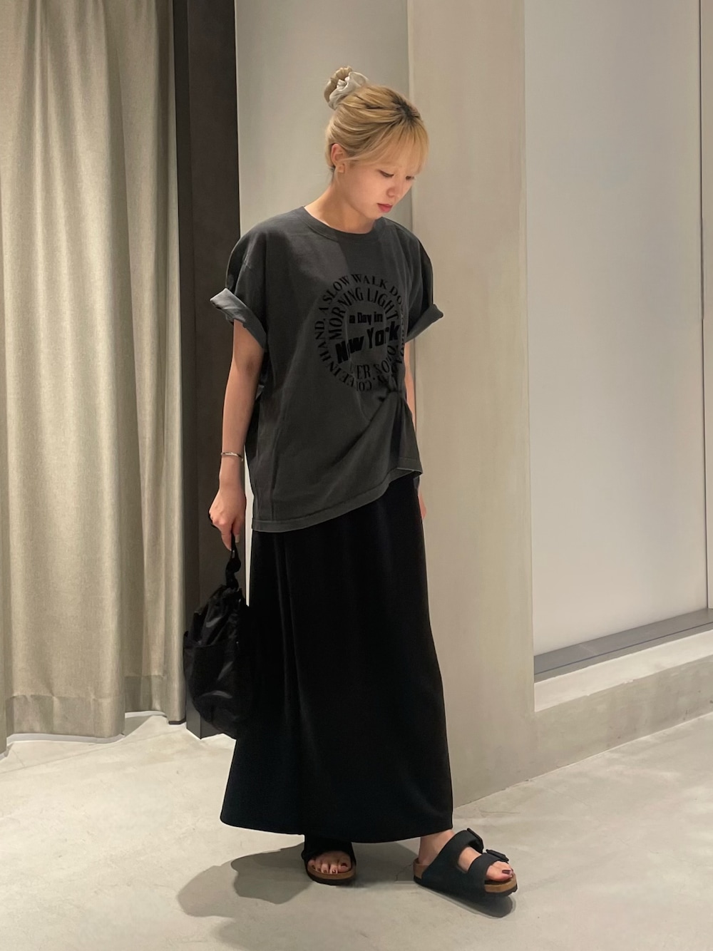 ブラック系のTシャツ/カットソー、ブラック系のスカート、ブラック系のショルダーバッグを着用したレディースの夏コーディネートの1枚目の写真