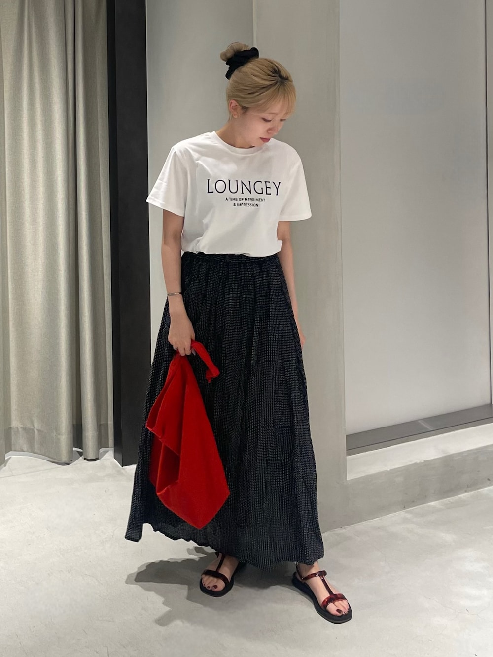 レッド系のショルダーバッグ、ブラック系のサンダル、ホワイト系のTシャツ/カットソーを着用したレディースの夏コーディネートの1枚目の写真