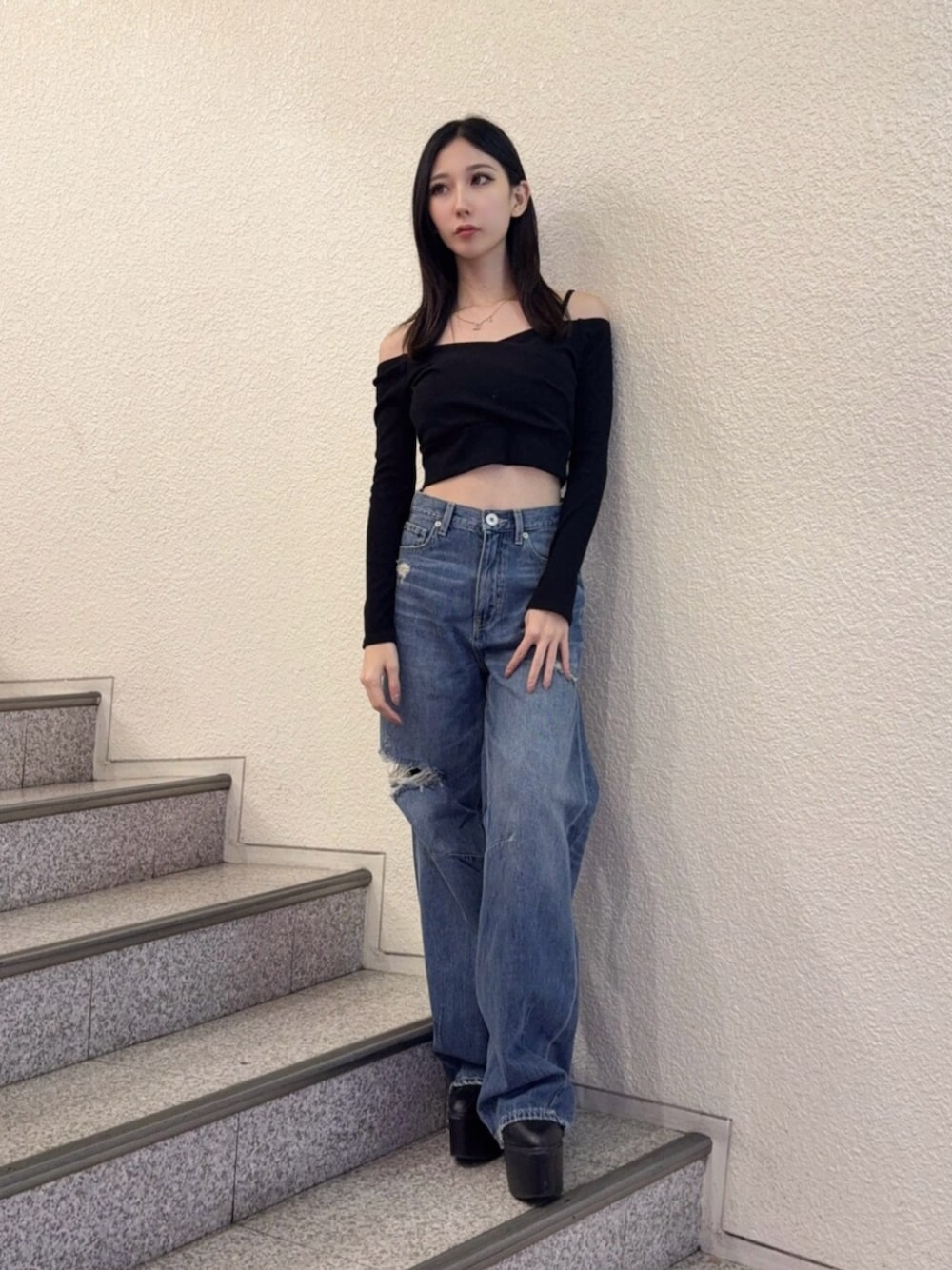 ブラック系のブーツ、ブルー系のデニムパンツ、ブラック系のTシャツ/カットソーを着用したレディースの秋コーディネートの1枚目の写真