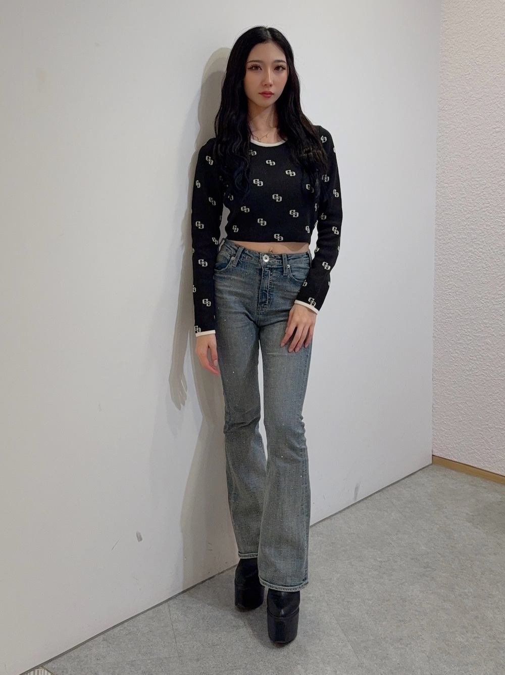 ブルー系のデニムパンツ、ブラック系のニット/セーター、ブラック系のブーツを着用したレディースの冬コーディネートの1枚目の写真