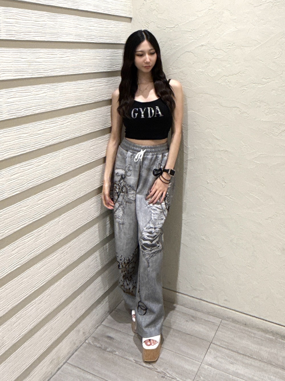 ブラック系のデニムパンツ、ブラック系のキャミソール、ホワイト系のサンダルを着用したレディースの夏コーディネートの1枚目の写真
