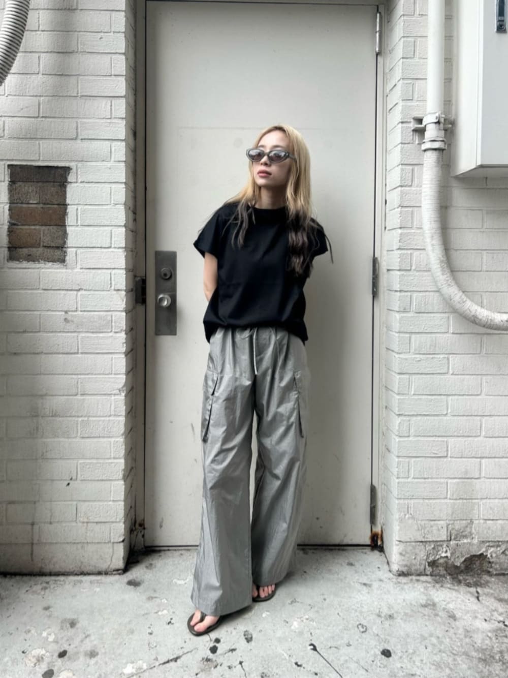 ブラック系のTシャツ/カットソー、グレー系のカーゴパンツ、グリーン系のサンダルを着用したレディースの夏コーディネートの1枚目の写真