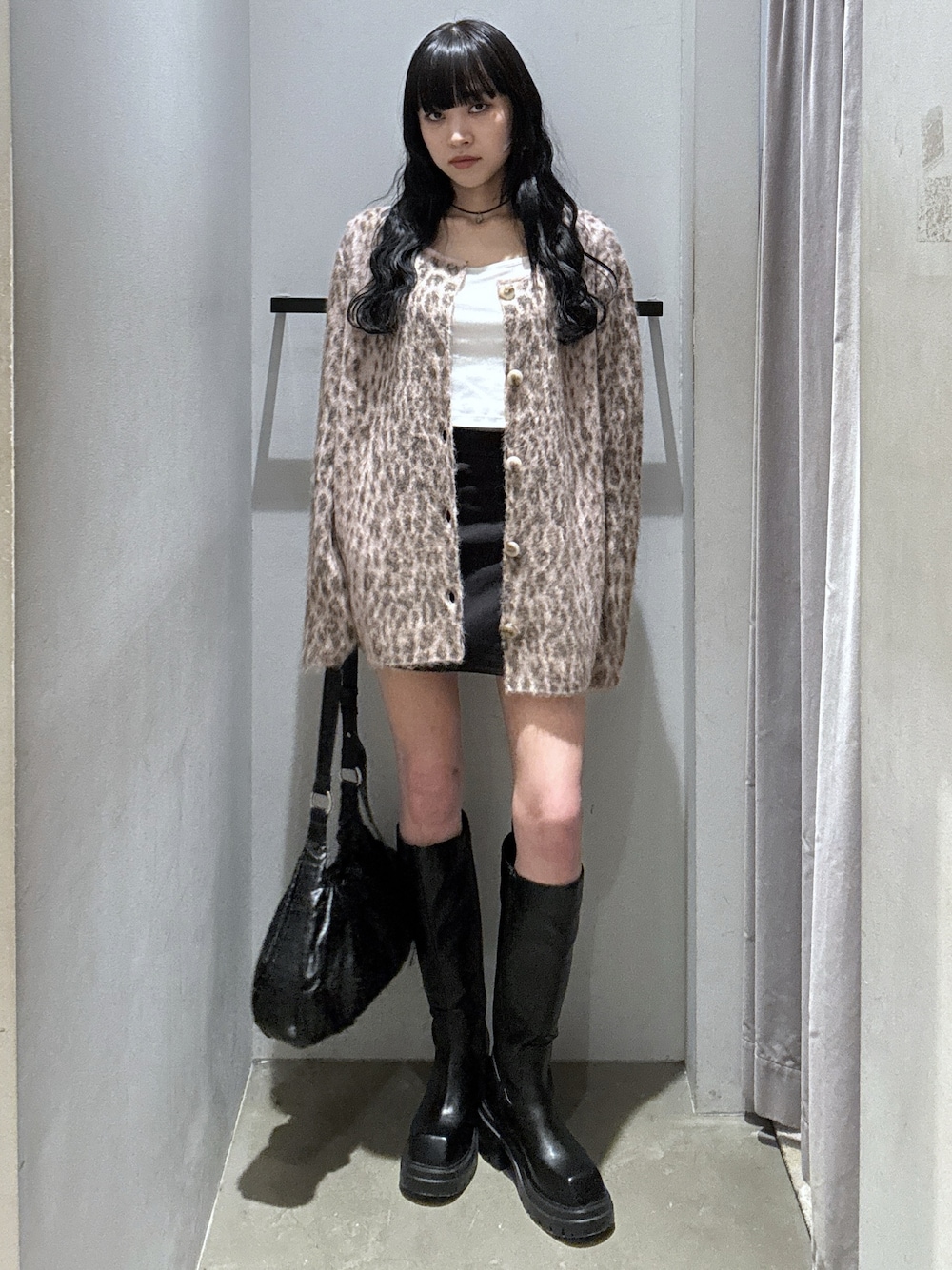 ピンク系のカーディガン/ボレロ、ブラック系のスカート、ブラック系のトートバッグを着用したレディースの秋コーディネートの1枚目の写真