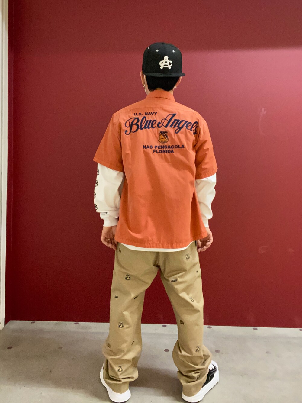 オレンジ系のシャツ/ブラウス、グリーン系のチノパンツを着用したメンズの春コーディネートの1枚目の写真