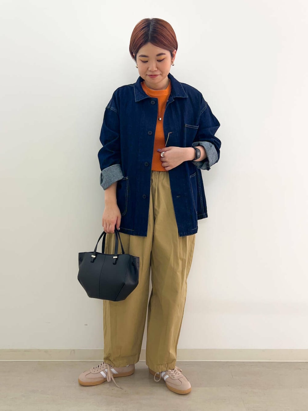 ブラック系のショルダーバッグ、グレー系のTシャツ/カットソー、オレンジ系のTシャツ/カットソーを着用したレディースの秋コーディネートの1枚目の写真
