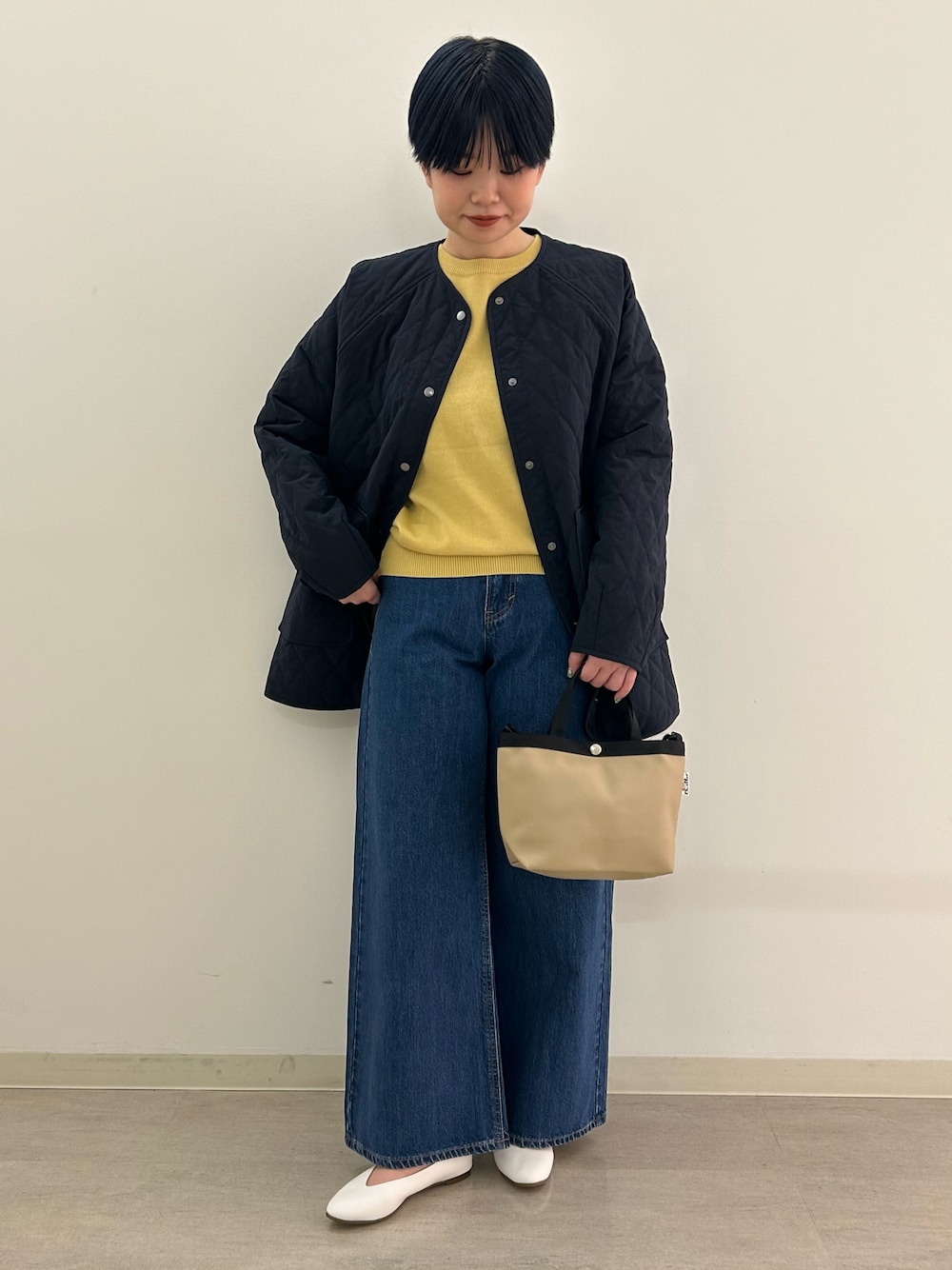 ホワイト系のパンプス、ブルー系のダウンジャケット/コート、ベージュ系のショルダーバッグを着用したレディースの冬コーディネートの1枚目の写真
