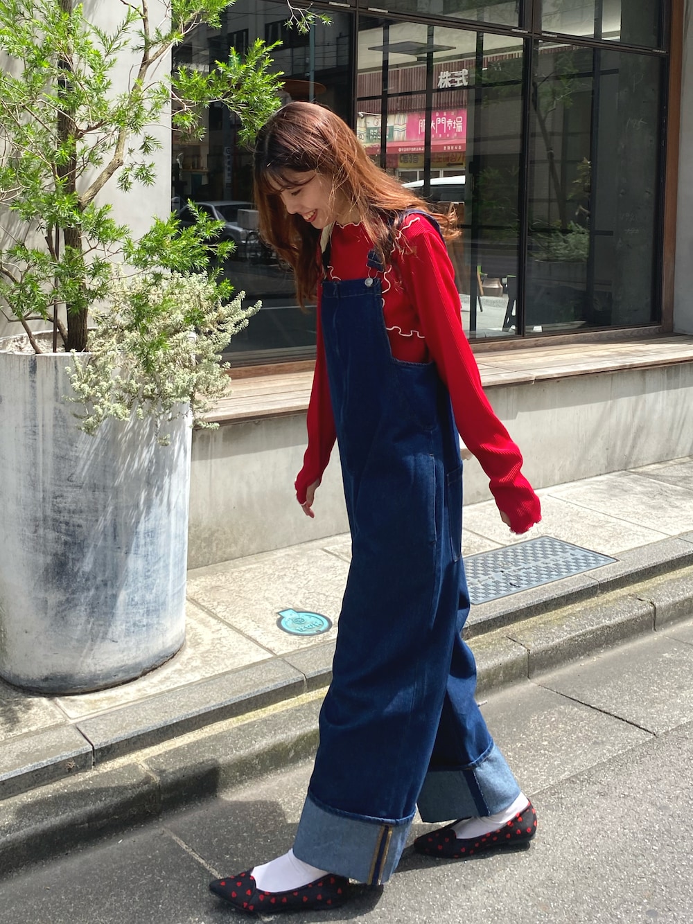 ブルー系のサロペット/オーバーオール、レッド系のTシャツ/カットソー、ブラック系のパンプスを着用したレディースの秋コーディネートの1枚目の写真