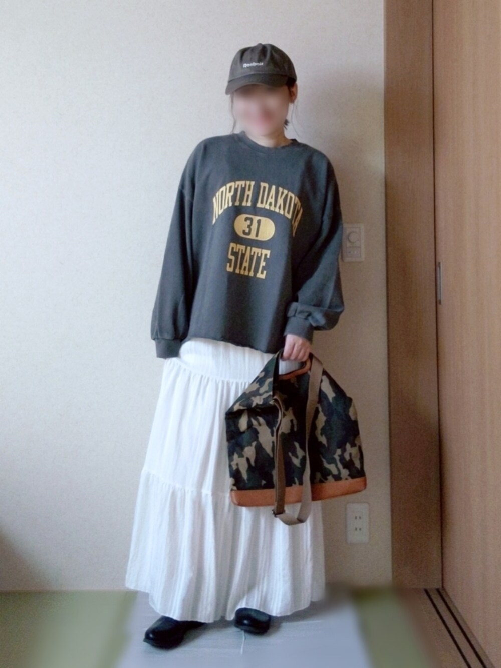 グレー系のスウェット、ホワイト系のスカート、その他のバッグを着用したレディースの冬コーディネートの2枚目の写真