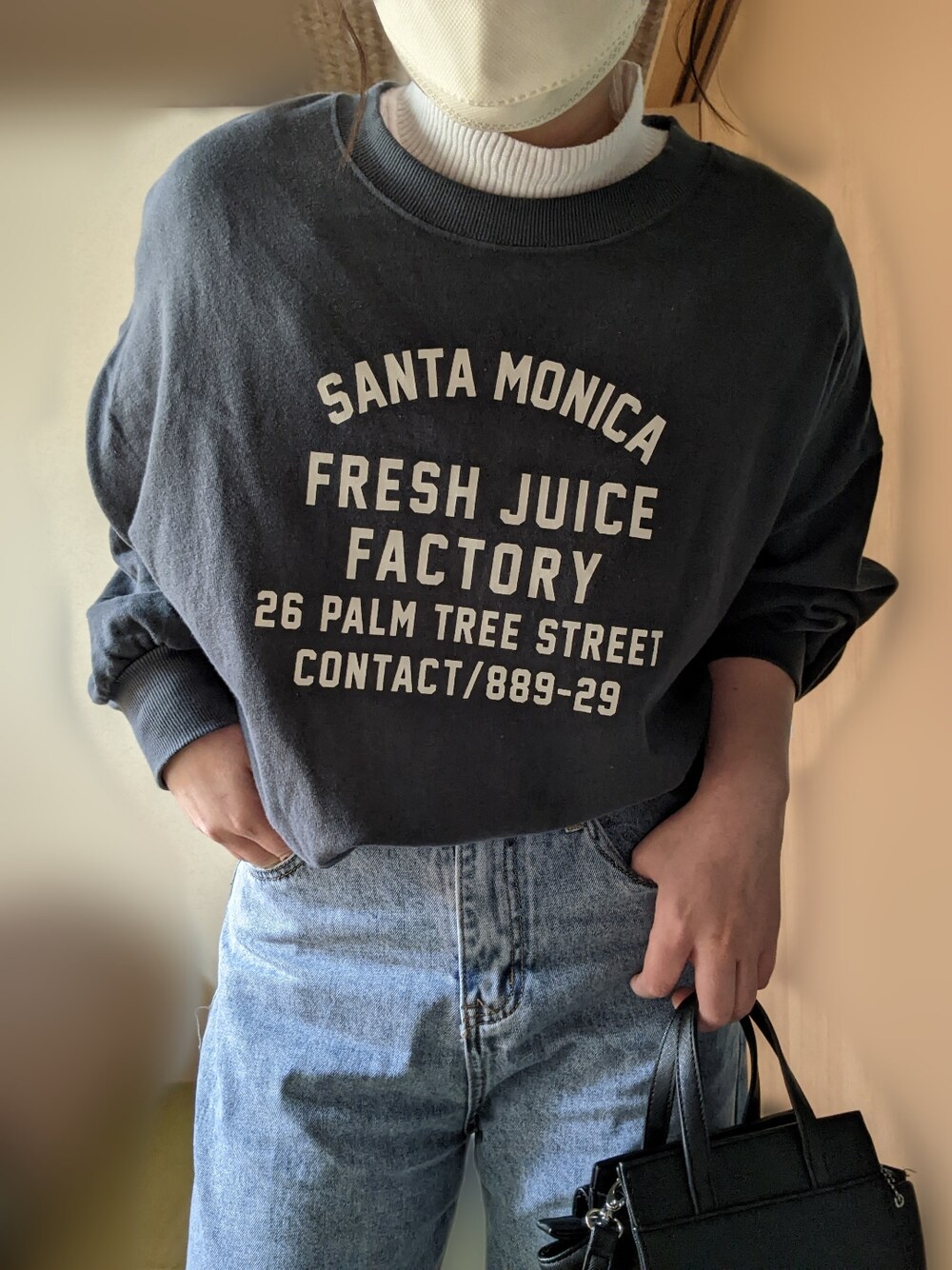 グレー系のスウェット、ブルー系のデニムパンツ、ブラック系のローファーを着用したレディースの冬コーディネートの2枚目の写真