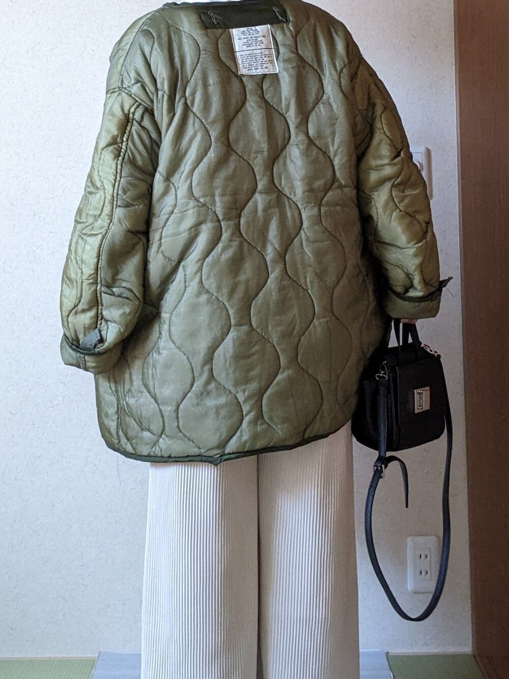 ブルー系のスウェット、グリーン系のジャケット/アウター、ベージュ系のパンツを着用したレディースの春コーディネートの2枚目の写真