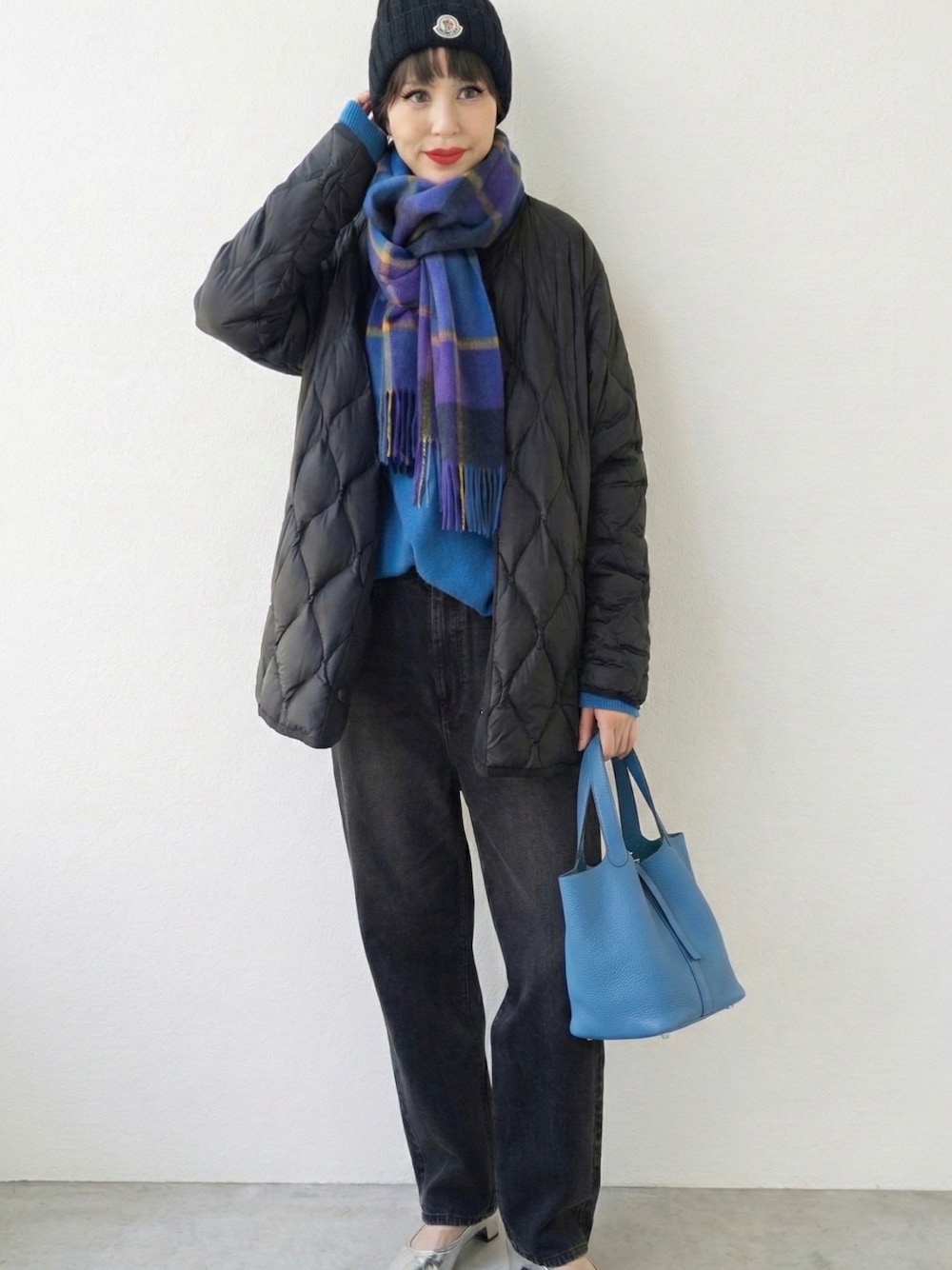 ブラック系のその他アウター、ブルー系のトートバッグ、ブルー系のマフラーを着用したレディースの冬コーディネートの1枚目の写真