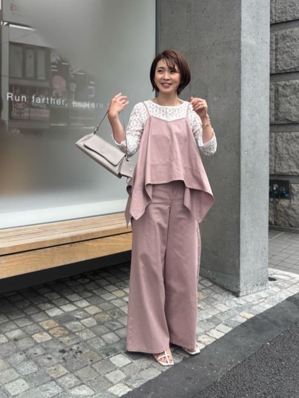 ベージュ系のショルダーバッグ、ホワイト系のTシャツ/カットソー、ピンク系のキャミソールを着用したレディースの夏コーディネートの1枚目の写真