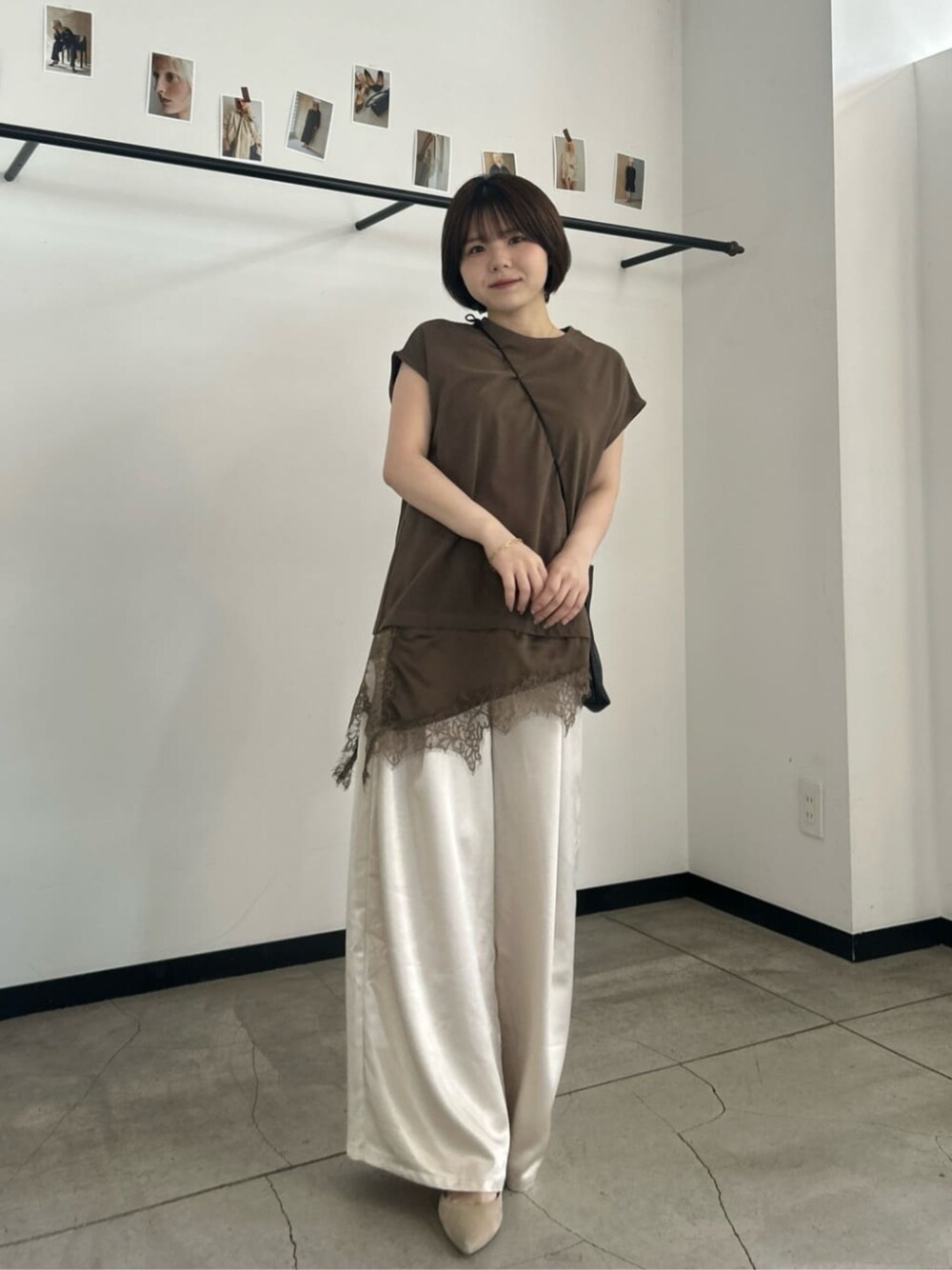ブラウン系のTシャツ/カットソー、ホワイト系のスラックスを着用したレディースの春コーディネートの1枚目の写真