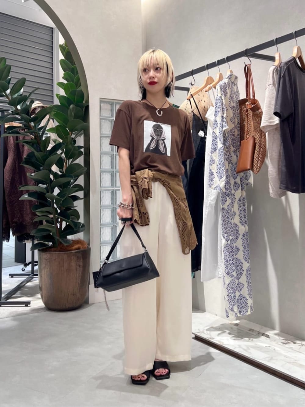 ブラック系のショルダーバッグ、ブラウン系のシャツ/ブラウス、ブラウン系のTシャツ/カットソーを着用したレディースの夏コーディネートの1枚目の写真