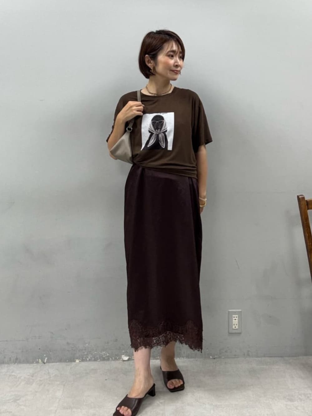 ベージュ系のショルダーバッグ、ブラウン系のTシャツ/カットソー、ブラウン系のワンピースを着用したレディースの夏コーディネートの1枚目の写真