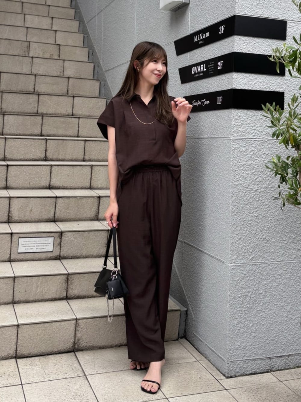 ブラック系のショルダーバッグ、ブラウン系のシャツ/ブラウスを着用したレディースの夏コーディネートの1枚目の写真