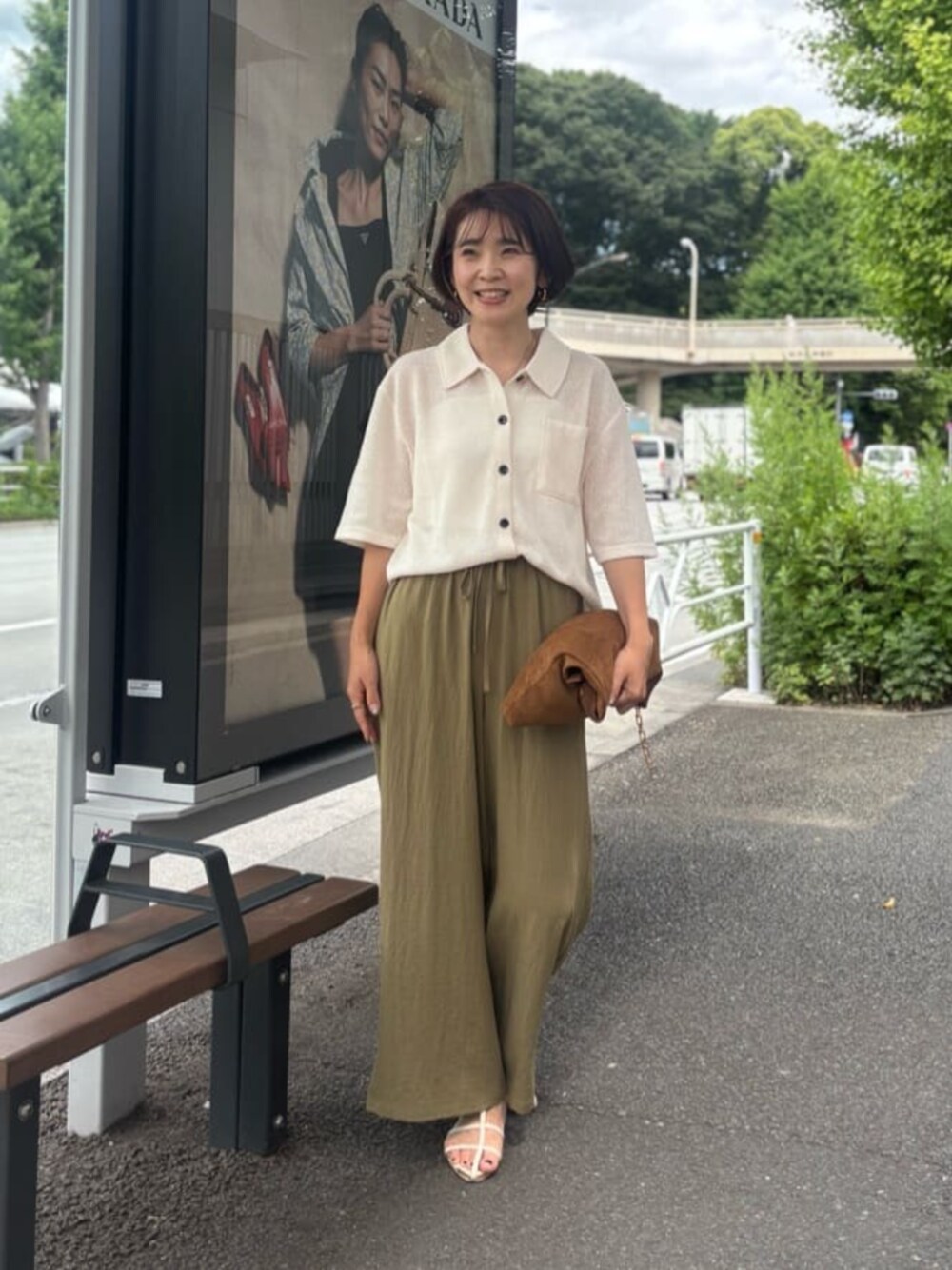 イエロー系のショルダーバッグ、ホワイト系のニット/セーターを着用したレディースの夏コーディネートの1枚目の写真