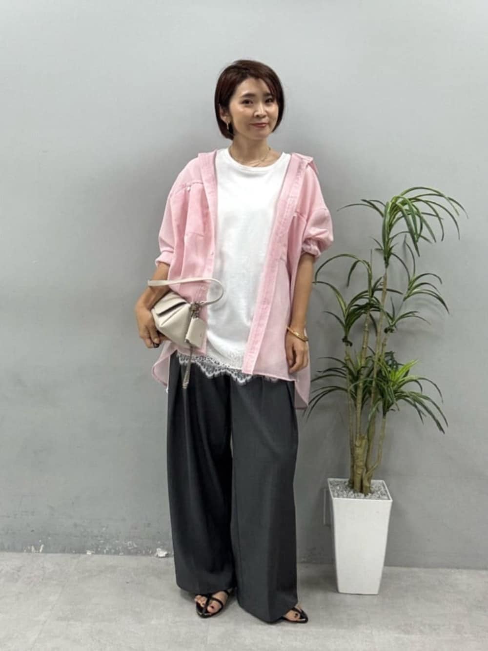 ホワイト系のショルダーバッグ、ピンク系のシャツ/ブラウス、ホワイト系のTシャツ/カットソーを着用したレディースの夏コーディネートの1枚目の写真