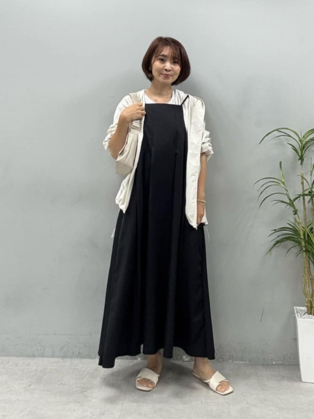 ホワイト系のショルダーバッグ、ブラック系のワンピース、その他のTシャツ/カットソーを着用したレディースの夏コーディネートの1枚目の写真