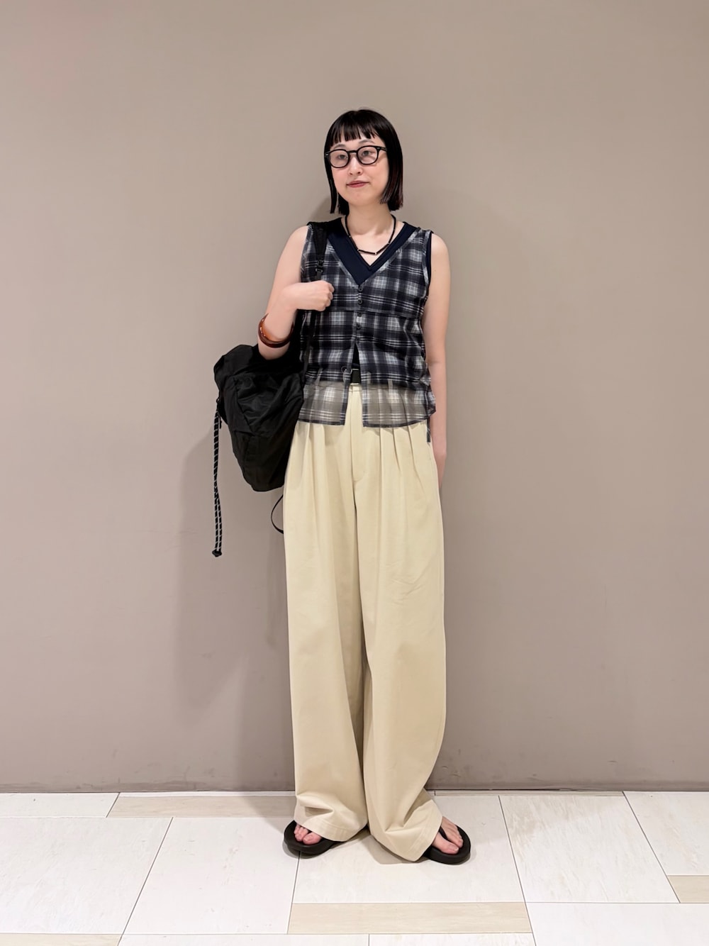 ベージュ系のその他パンツ、ブルー系のタンクトップ、ブラック系のバックパック/リュックを着用したレディースの夏コーディネートの1枚目の写真
