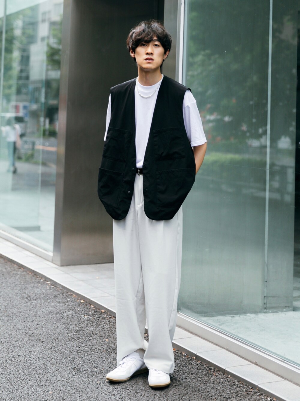 ブラック系のベスト、ホワイト系のTシャツ/カットソー、ホワイト系のスニーカーを着用したメンズの秋コーディネートの1枚目の写真