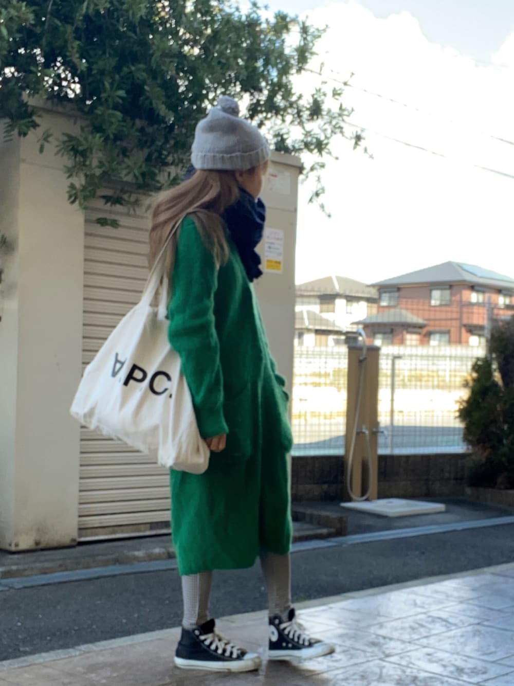 ホワイト系のトートバッグ、グリーン系のその他アウター、ブラック系のスニーカーを着用したレディースの冬コーディネートの1枚目の写真