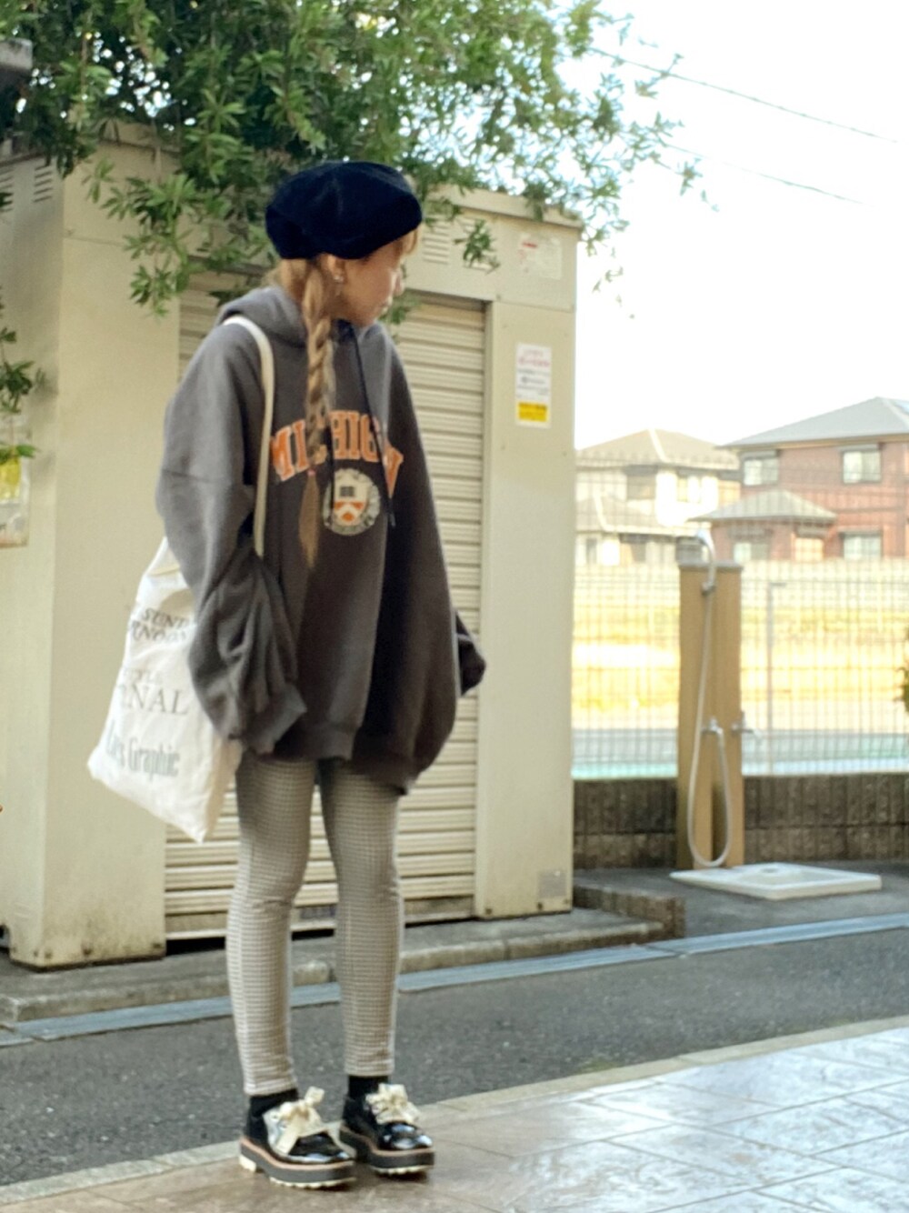 グレー系のパーカー、ホワイト系のトートバッグ、ブラック系のドレスシューズを着用したレディースの冬コーディネートの1枚目の写真