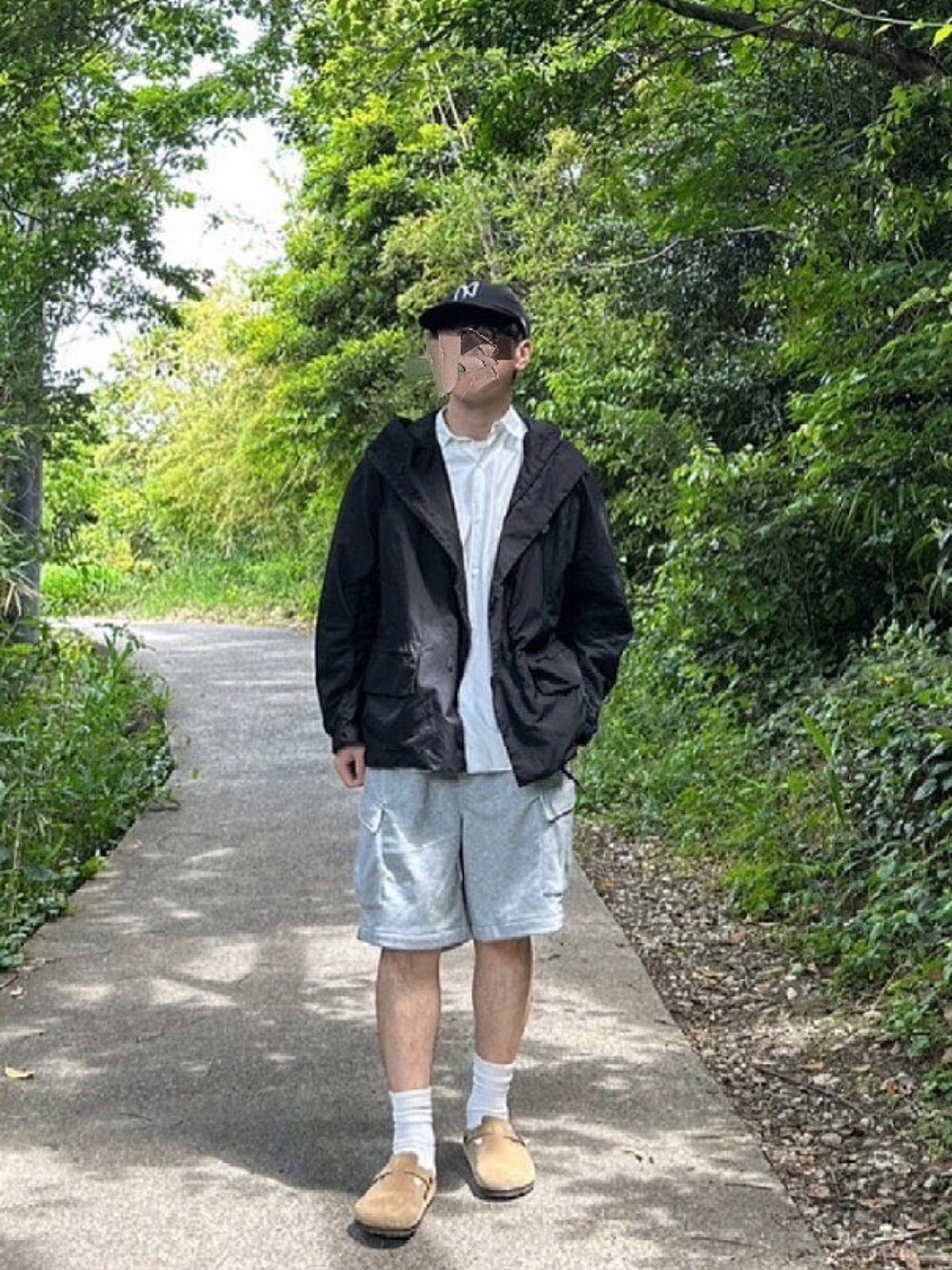 ブラック系のブルゾン、グレー系のその他パンツ、ベージュ系のスリッポンを着用したメンズの夏コーディネートの1枚目の写真