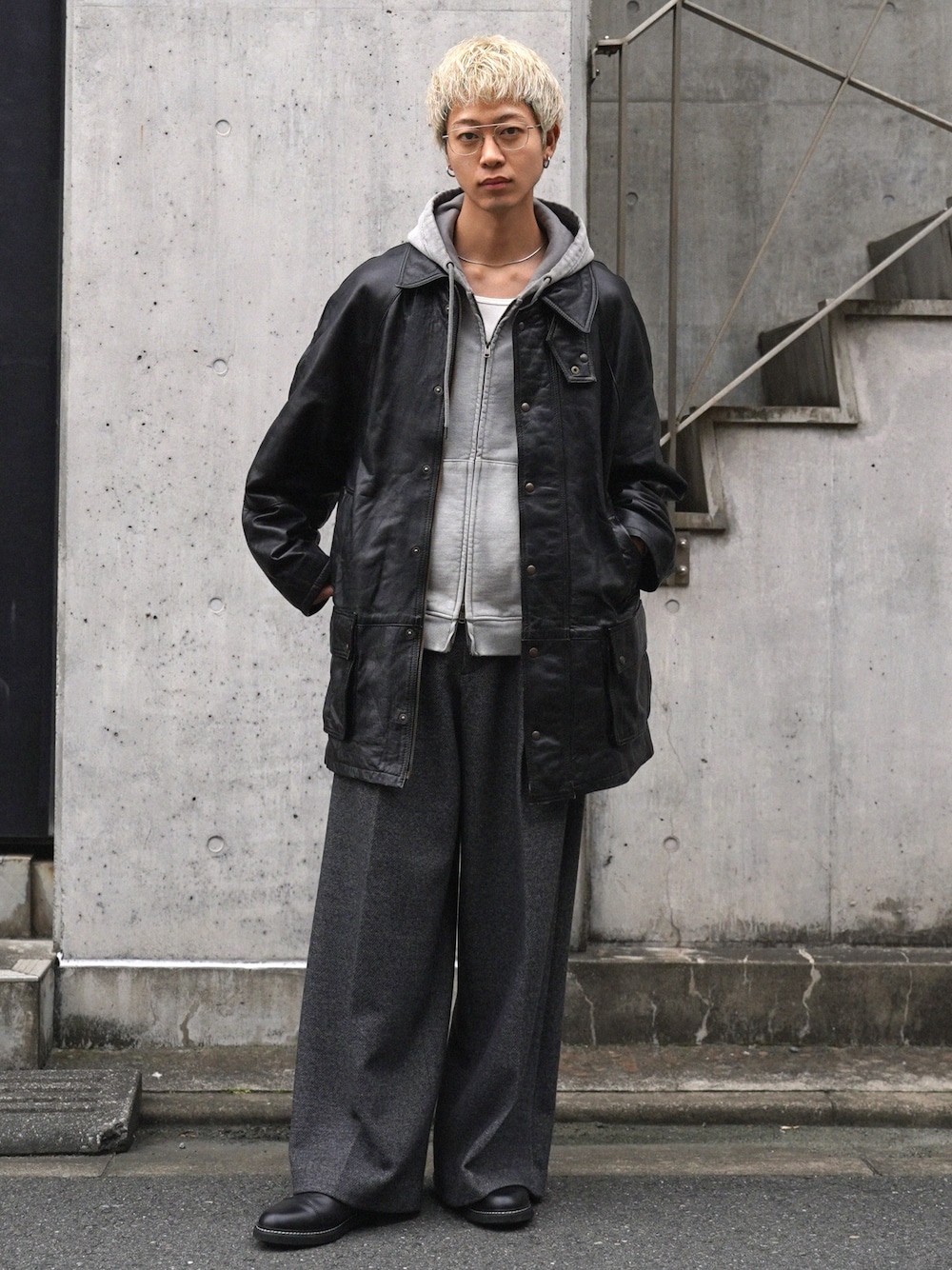 ブラック系のジャケット/アウター、グレー系のパーカー、グレー系のスラックスを着用したメンズの冬コーディネートの1枚目の写真