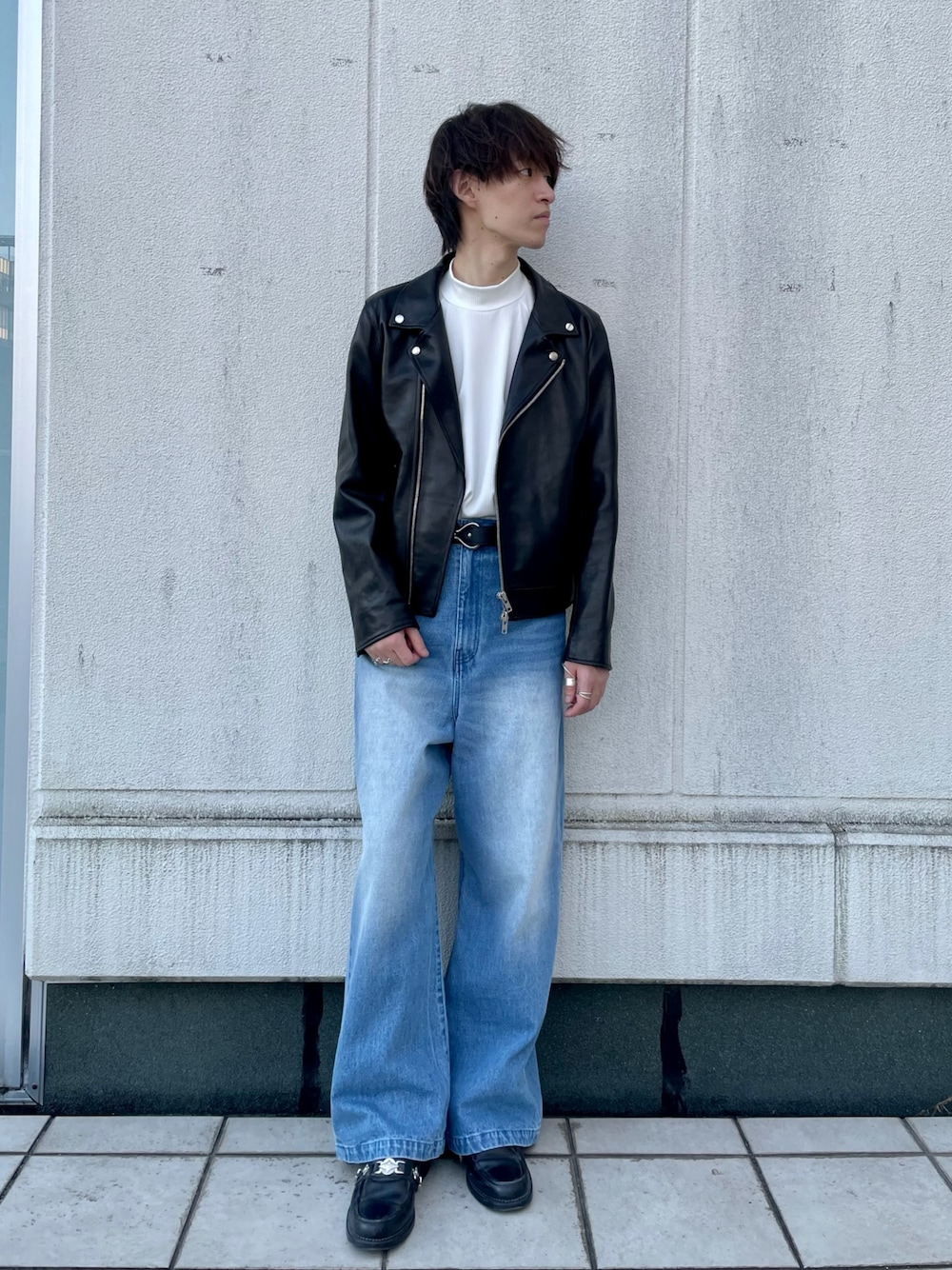 ブラック系のライダースジャケット、ブラック系のデニムパンツ、ブラック系のベルトを着用したメンズの秋コーディネートの1枚目の写真