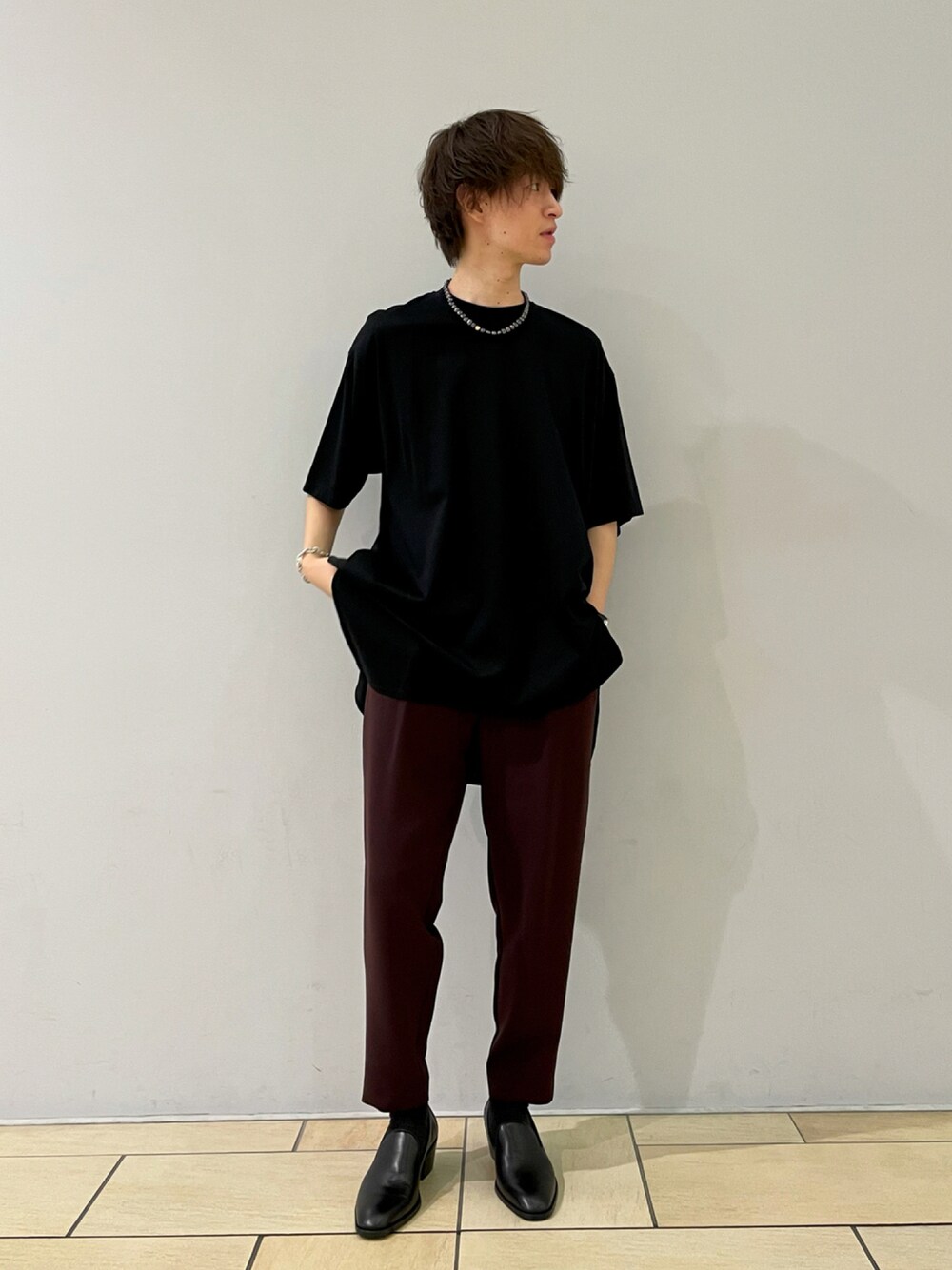 ブラック系のTシャツ/カットソー、レッド系のスラックス、ブラック系のドレスシューズを着用したメンズの夏コーディネートの1枚目の写真