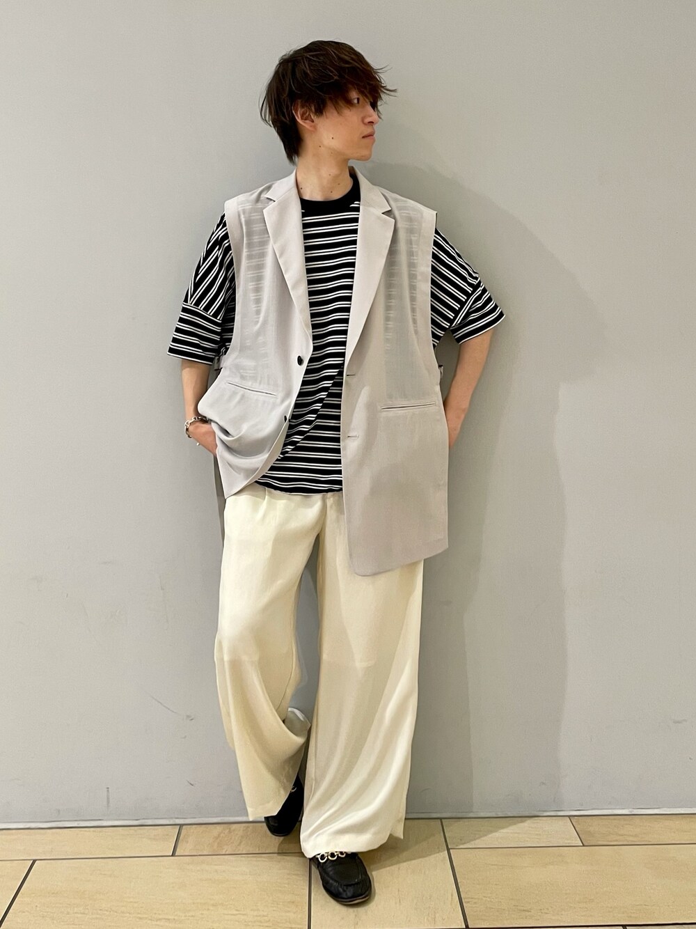 ホワイト系のスラックス、ブラック系のTシャツ/カットソー、グレー系のベストを着用したメンズの夏コーディネートの1枚目の写真