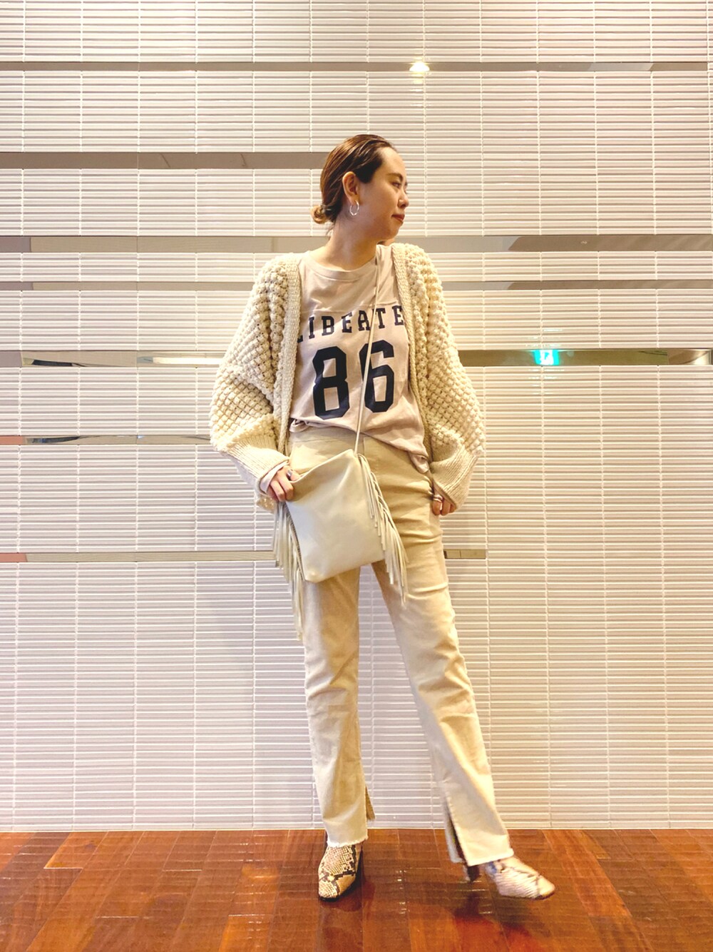 ホワイト系のその他パンツ、ベージュ系のTシャツ/カットソー、ホワイト系のカーディガン/ボレロを着用したレディースの秋コーディネートの1枚目の写真
