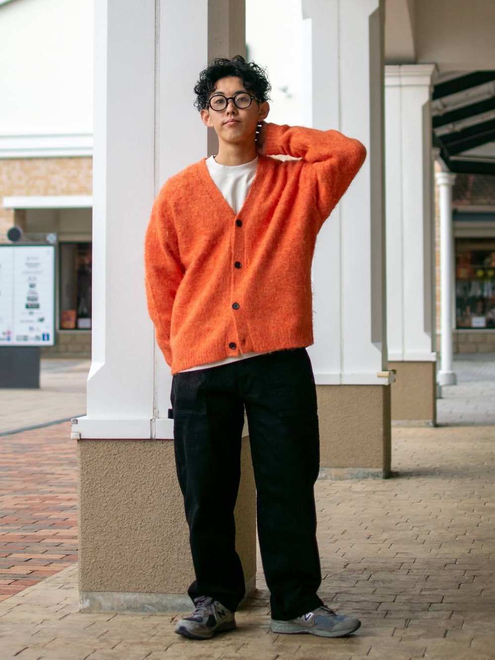ブラック系のデニムパンツ、ホワイト系のスウェット、オレンジ系のカーディガン/ボレロを着用したメンズの冬コーディネートの1枚目の写真