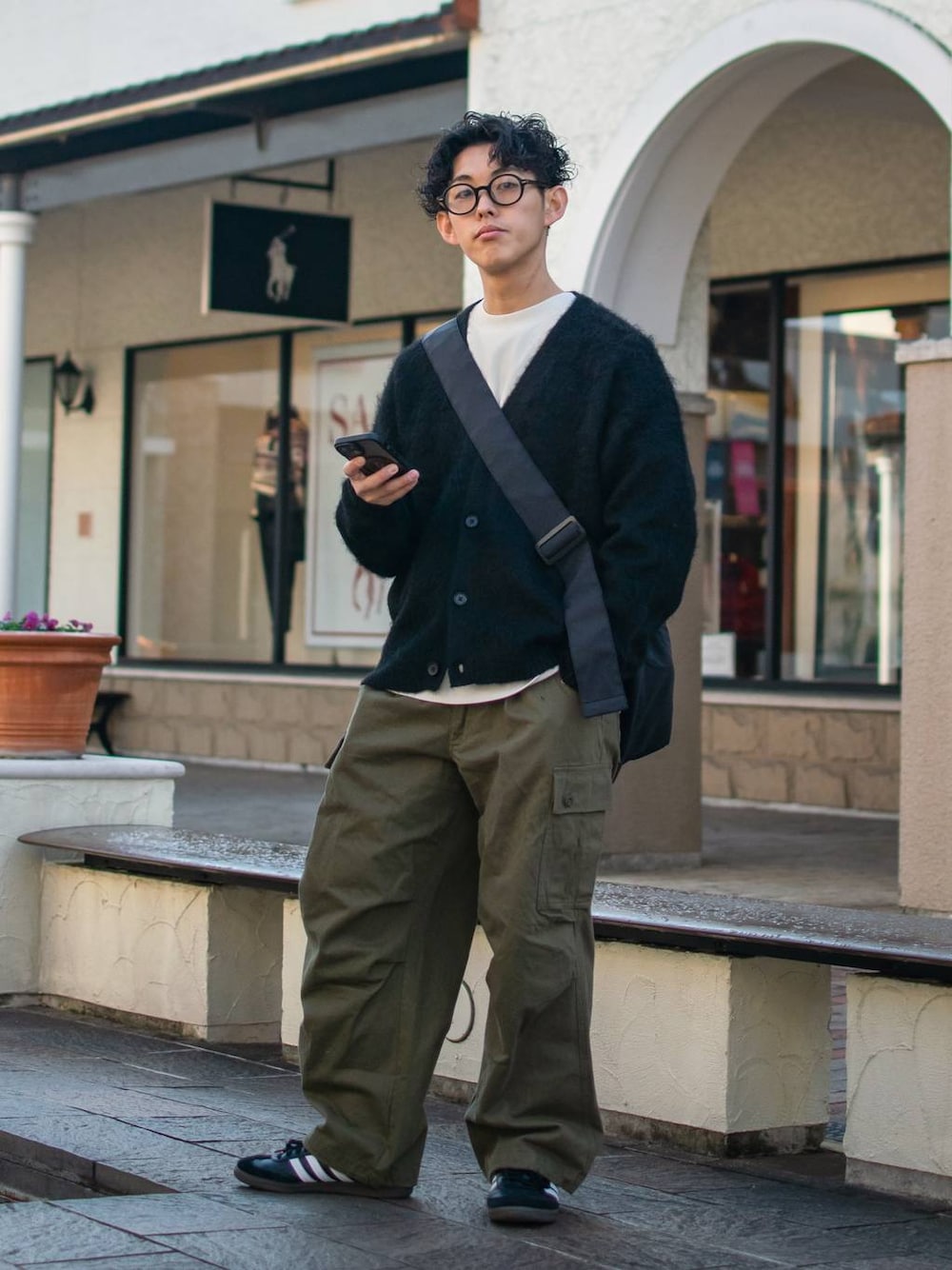 ブラック系のショルダーバッグ、グリーン系のカーゴパンツ、ホワイト系のスウェットを着用したメンズの冬コーディネートの1枚目の写真