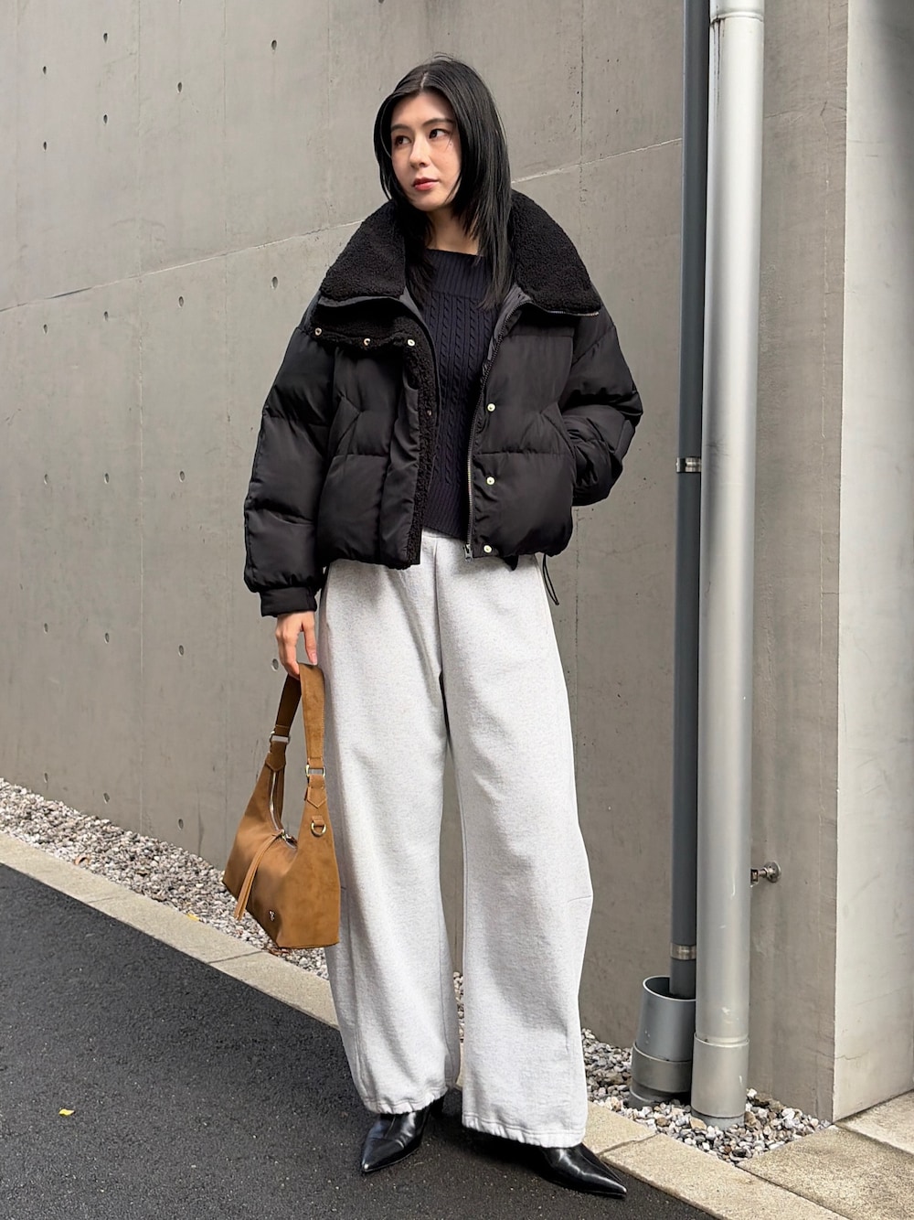 ブラック系のダウンジャケット/コート、グレー系のスウェットパンツ、ブラック系のブーツを着用したレディースの秋コーディネートの1枚目の写真