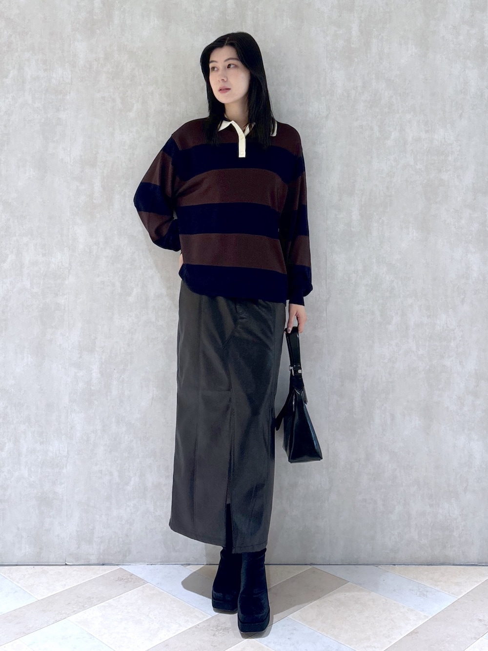 ブラウン系のニット/セーター、ブラック系のスカート、ブラック系のショルダーバッグを着用したレディースの秋コーディネートの1枚目の写真