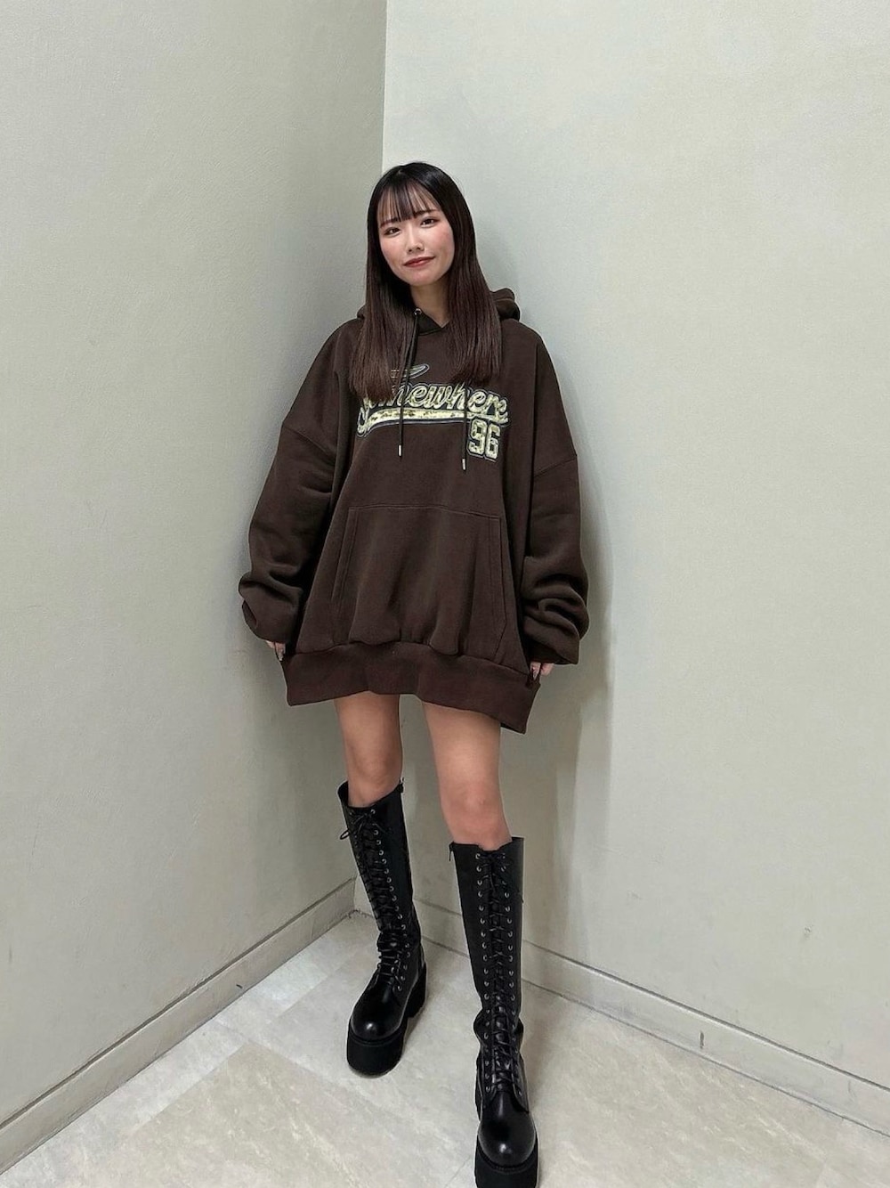 ブラック系のブーツ、ブラウン系のパーカーを着用したレディースの冬コーディネートの1枚目の写真