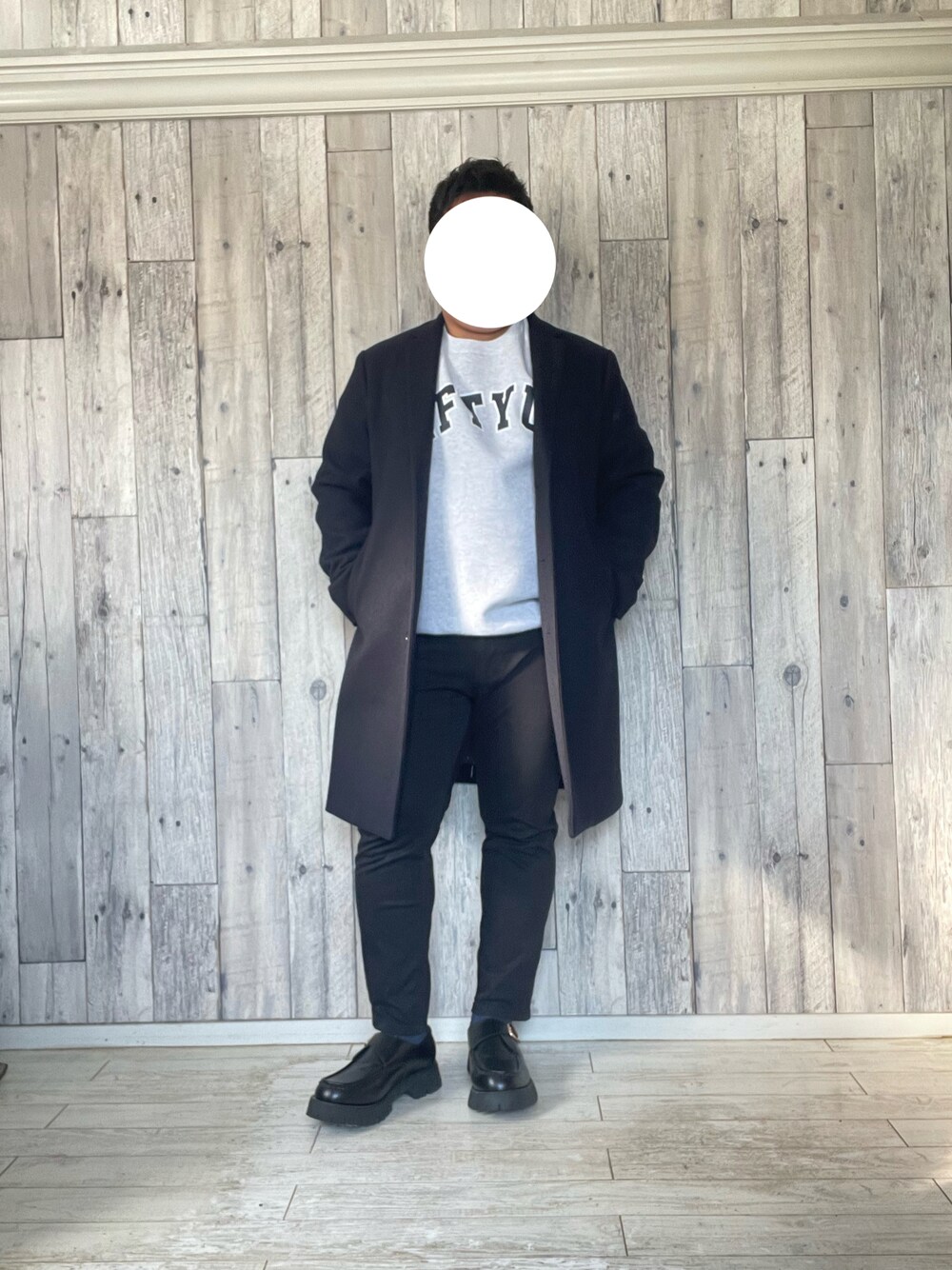ブルー系のチェスターコート、グレー系のスウェット、ブラック系のパンツを着用したメンズの冬コーディネートの1枚目の写真
