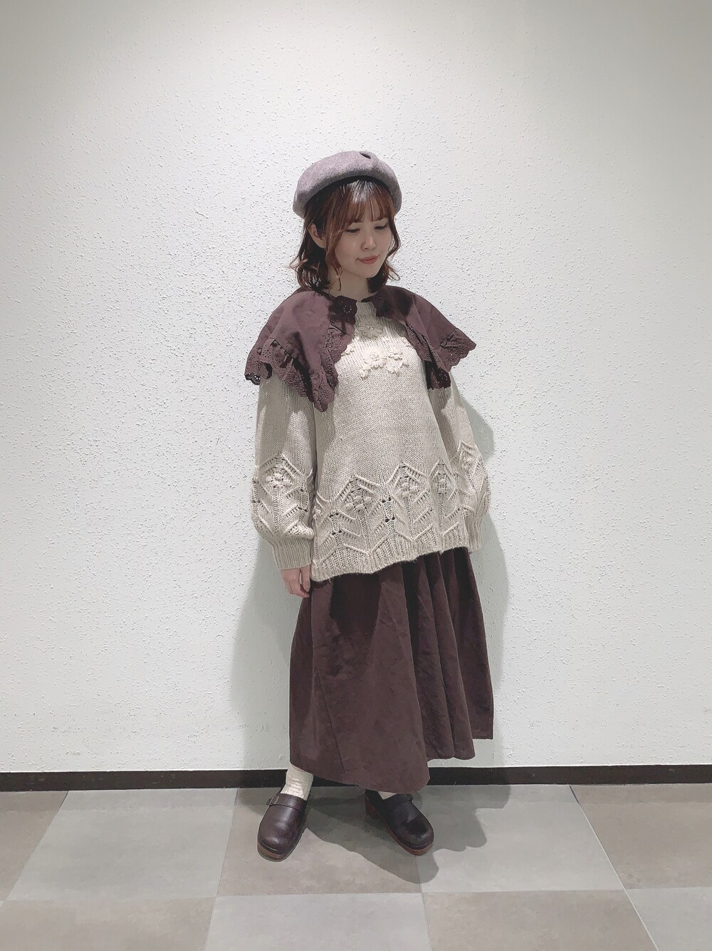 ホワイト系のニット/セーター、ブラウン系のワンピース、ブラウン系のサンダルを着用したレディースの秋コーディネートの1枚目の写真