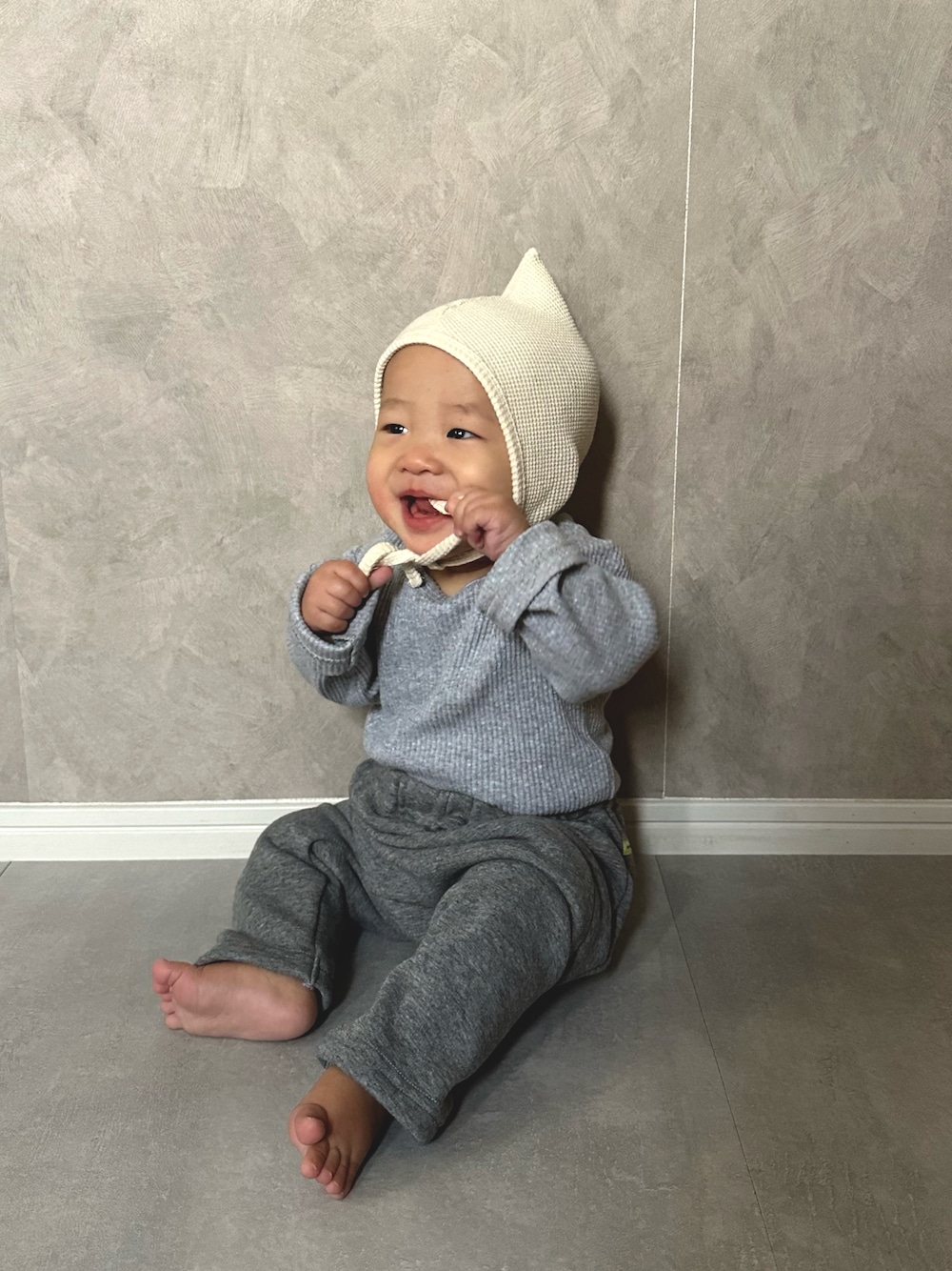 グレー系のロンパース、グレー系のその他ベビーウェアを着用したキッズの秋コーディネートの1枚目の写真