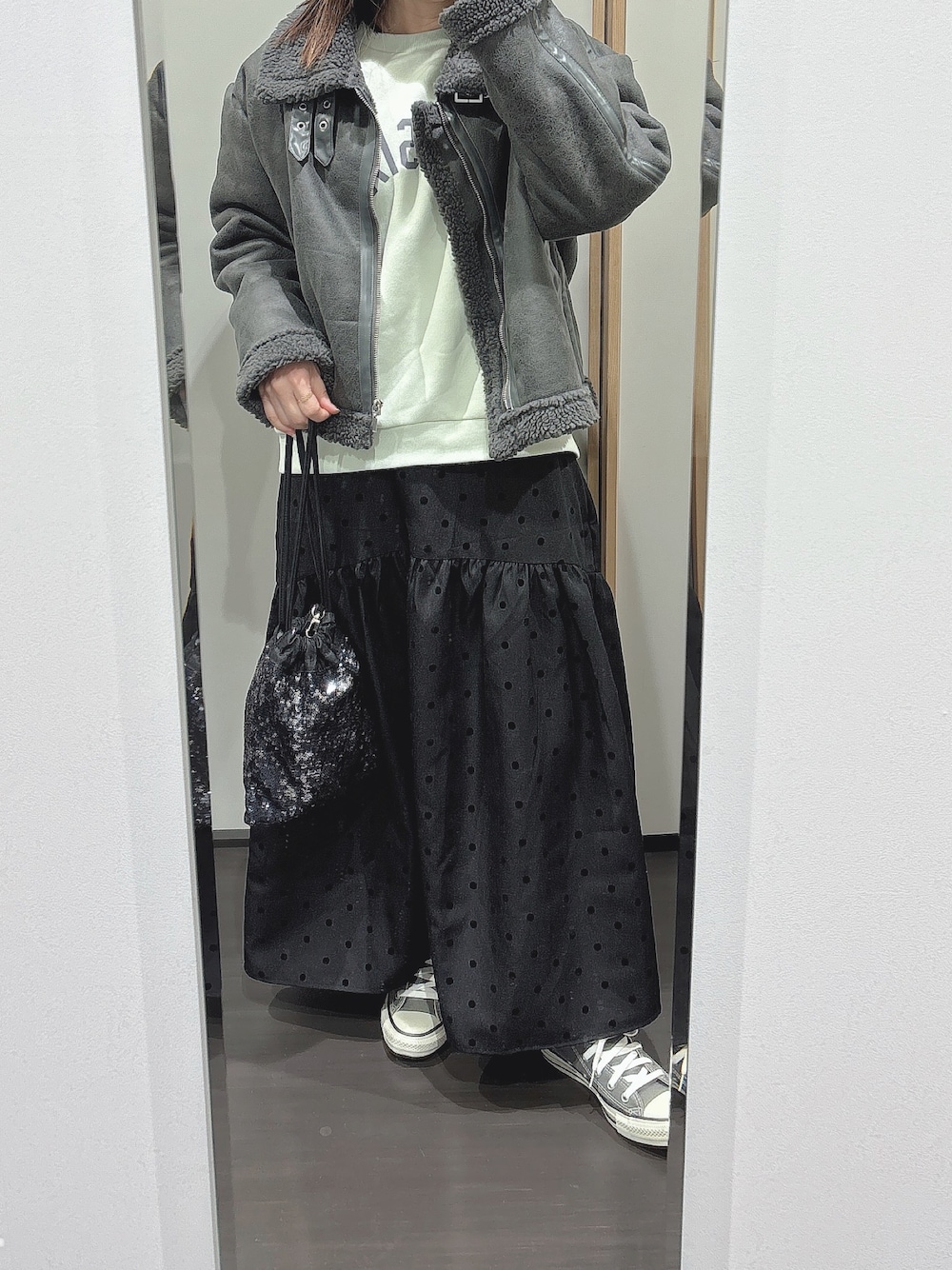 グリーン系のTシャツ/カットソー、ブラック系のスカート、グレー系のブルゾンを着用したレディースの春コーディネートの1枚目の写真