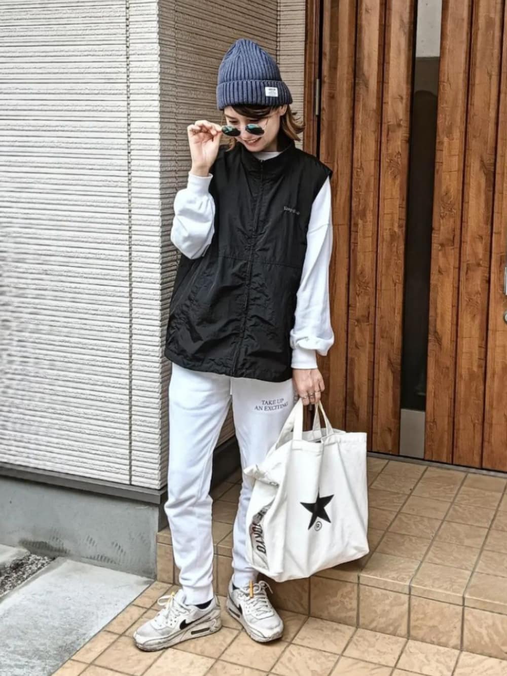 ブラック系のベスト、ホワイト系のスウェット、ホワイト系のその他パンツを着用したレディースの秋コーディネートの1枚目の写真