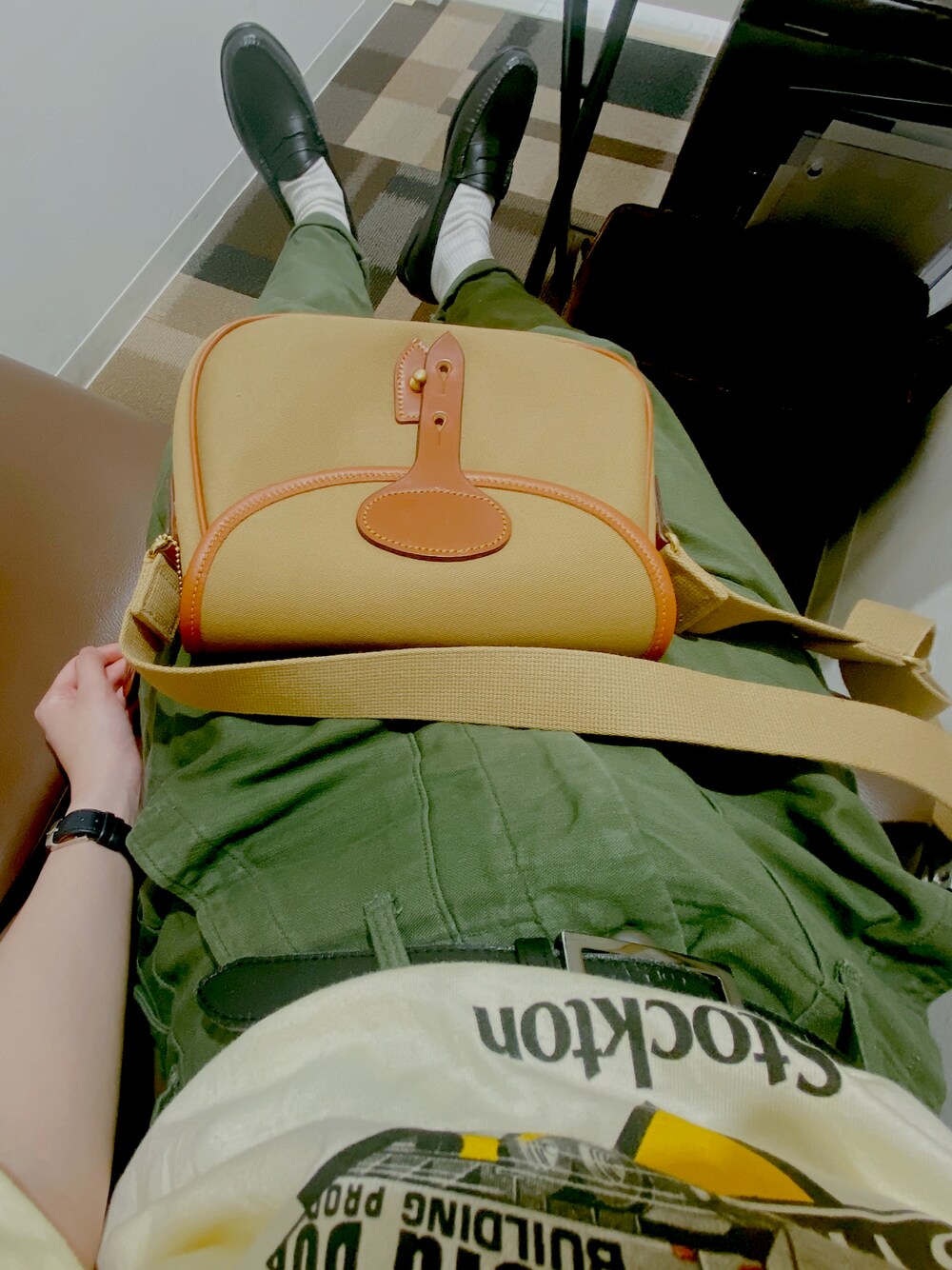 グリーン系のショルダーバッグ、ブラック系のローファーを着用したレディースの夏コーディネートの1枚目の写真