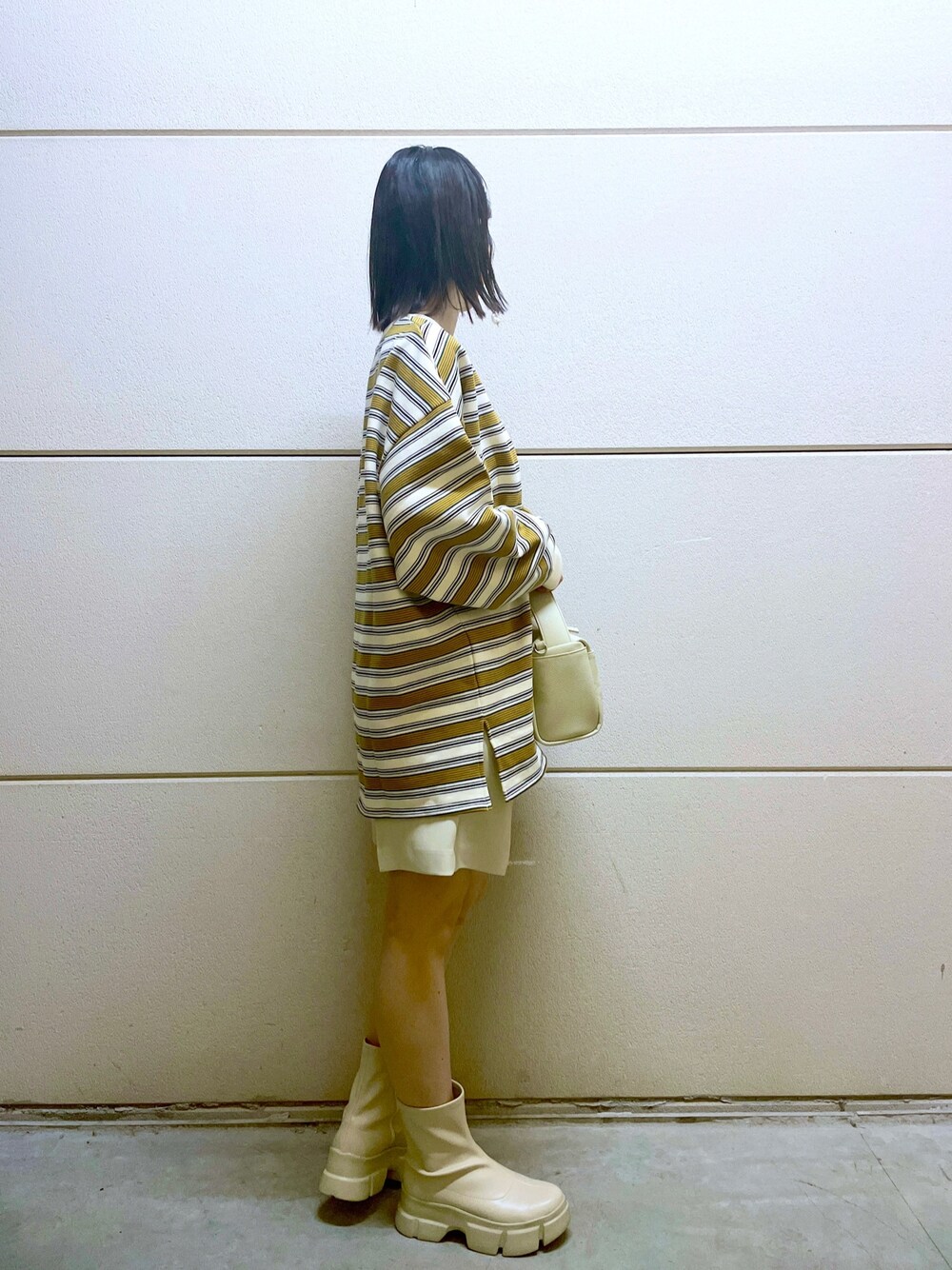 イエロー系のニット/セーター、ホワイト系のスウェット、ホワイト系のその他パンツを着用したレディースの冬コーディネートの5枚目の写真