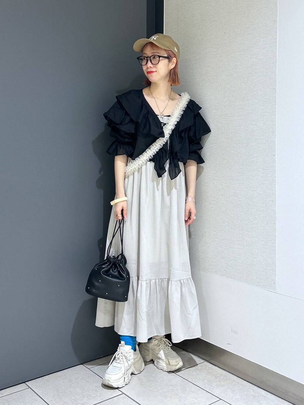 ホワイト系のワンピース、ホワイト系のスニーカー、ブラック系のショルダーバッグを着用したレディースの春コーディネートの1枚目の写真
