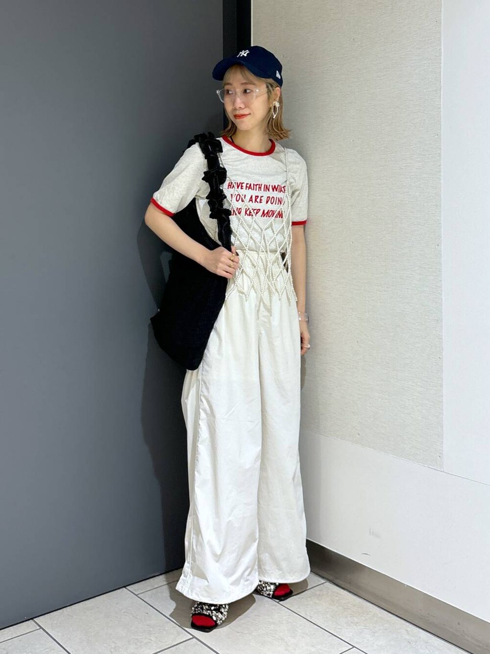 ブラック系のトートバッグ、ホワイト系のTシャツ/カットソー、ホワイト系のベストを着用したレディースの夏コーディネートの1枚目の写真