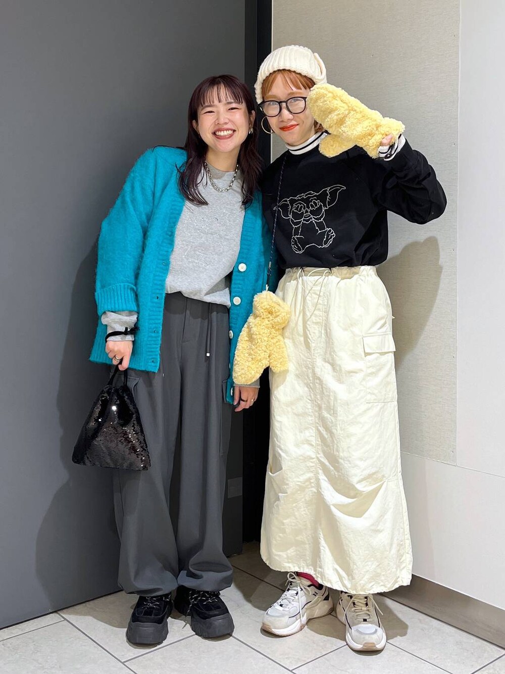 グレー系のニット/セーター、ブラック系のハンドバッグ、グレー系のカーゴパンツを着用したレディースの冬コーディネートの1枚目の写真