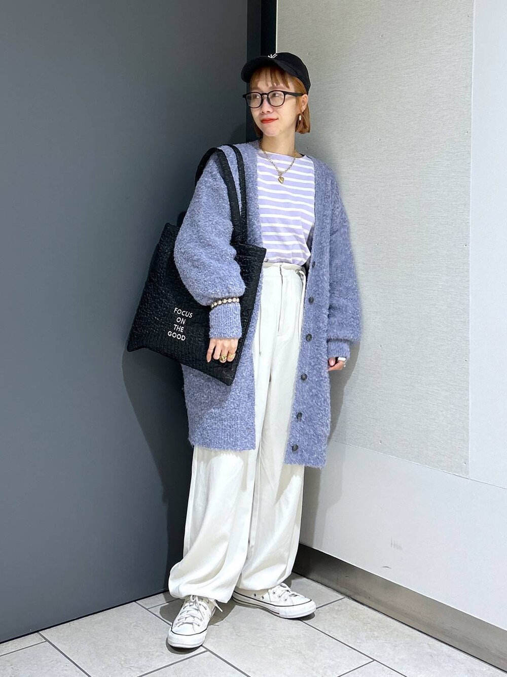 ブラック系のトートバッグ、パープル系のTシャツ/カットソー、パープル系のチュニックを着用したレディースの秋コーディネートの1枚目の写真