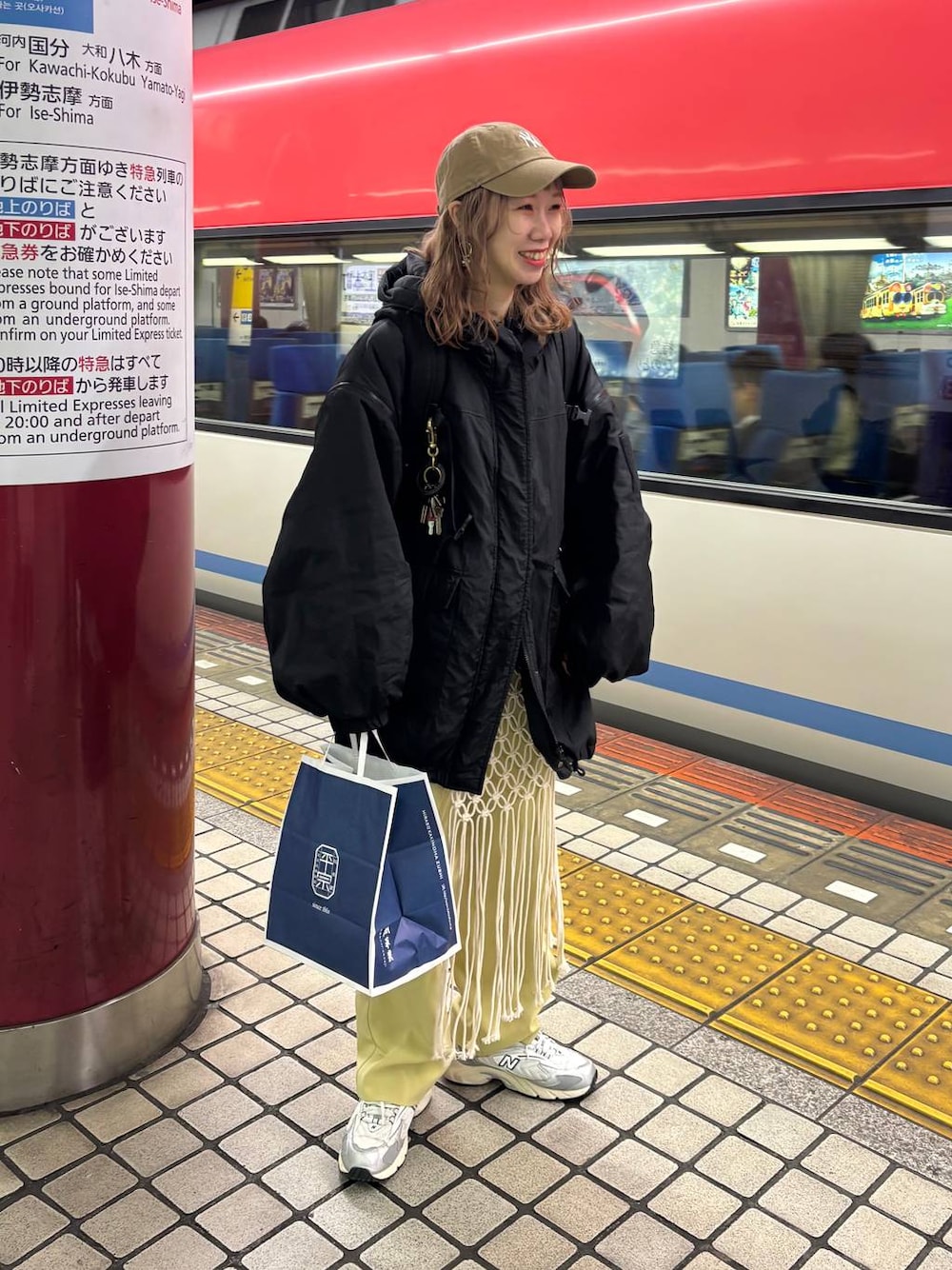 グレー系のスニーカー、ブラック系のブルゾン、ベージュ系のキャップを着用したレディースの春コーディネートの1枚目の写真